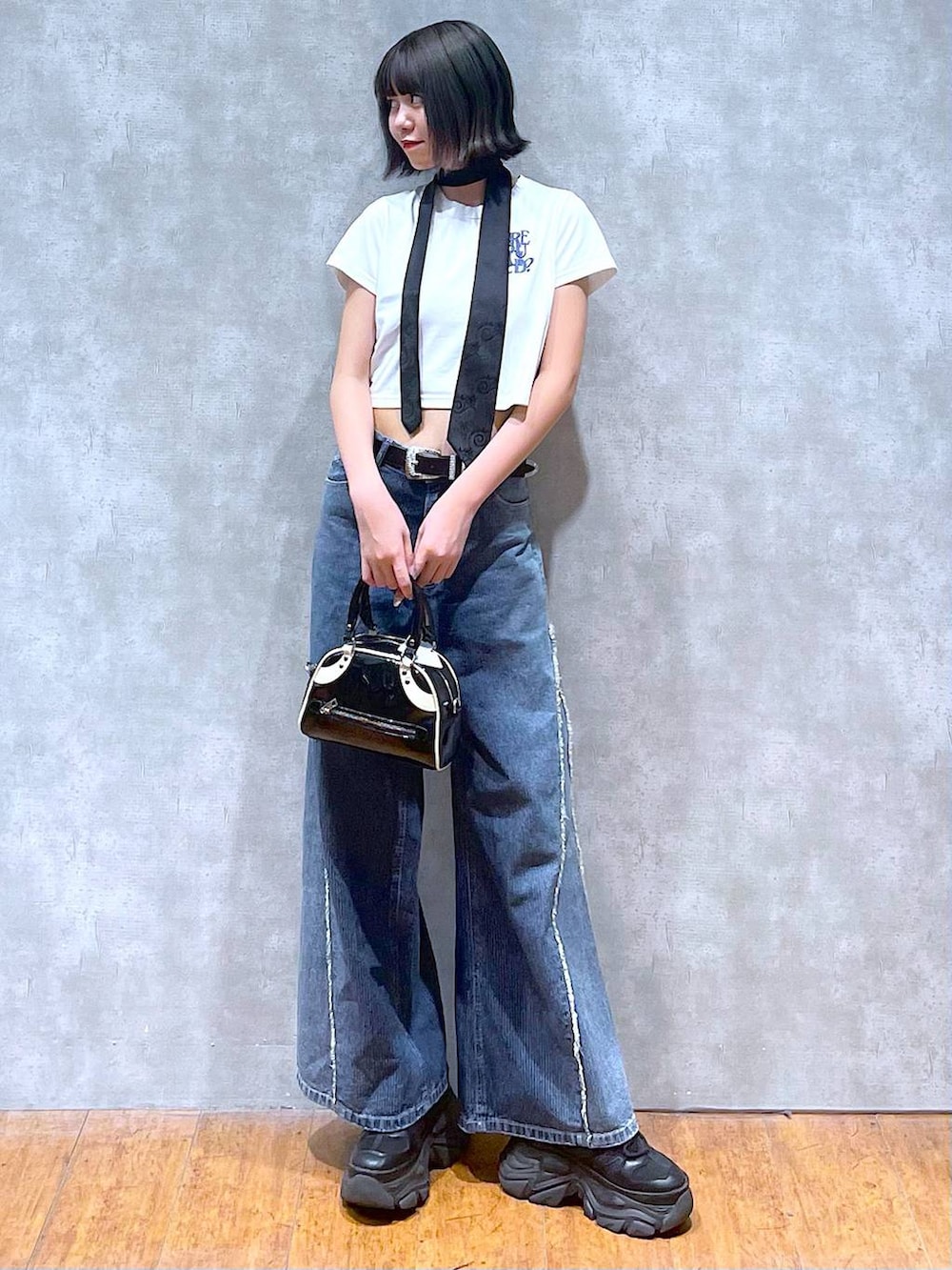 ブラック系のスニーカー、ホワイト系のTシャツ/カットソー、ブラック系のネクタイを着用したレディースの夏コーディネートの2枚目の写真