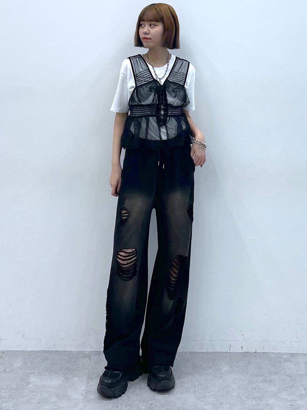 ブラック系のスニーカー、ブラック系のベスト、ホワイト系のTシャツ/カットソーを着用したレディースの夏コーディネートの3枚目の写真