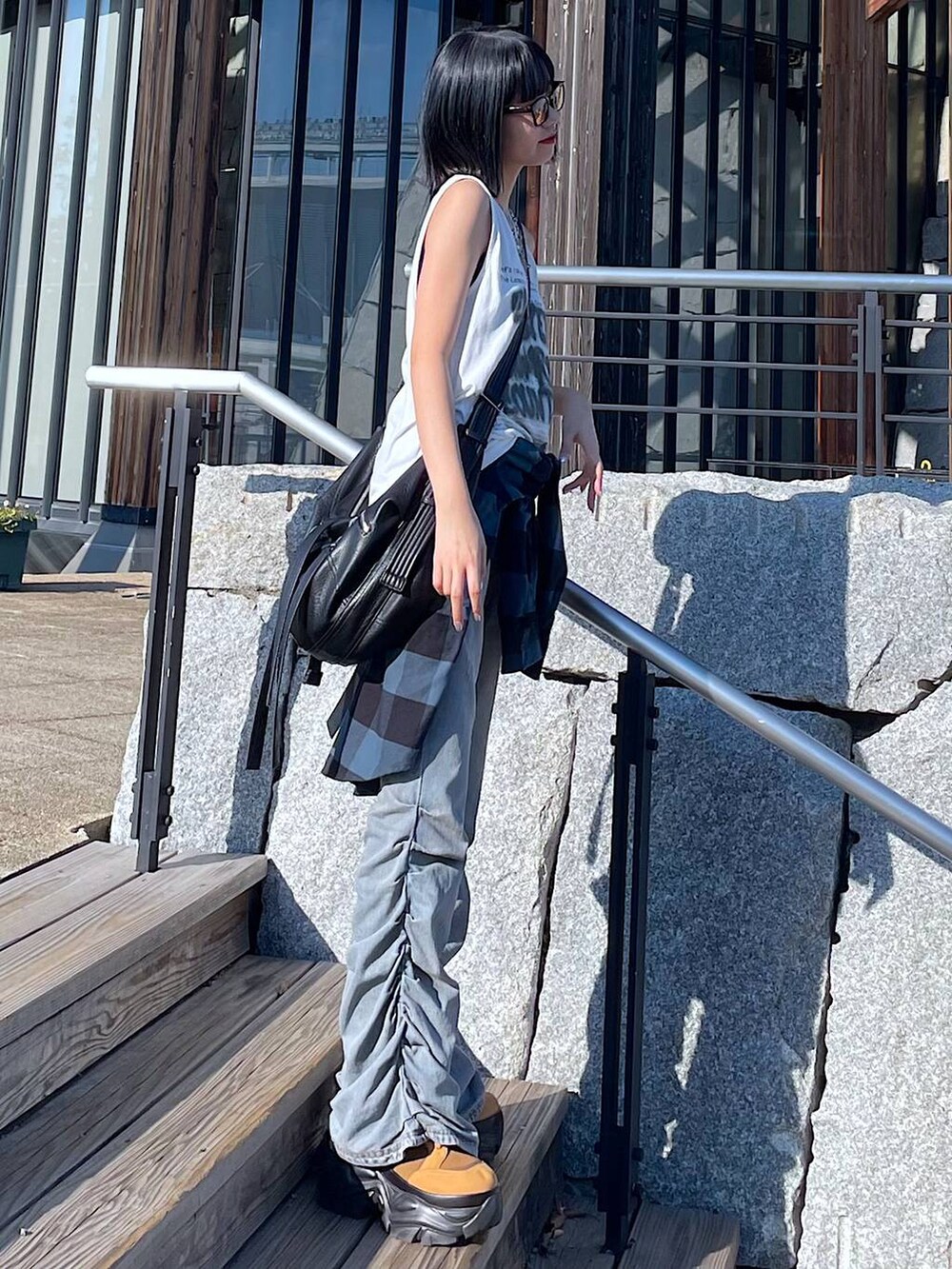 ホワイト系のTシャツ/カットソー、ブルー系のデニムパンツ、ブラウン系のブーツを着用したレディースの秋コーディネートの7枚目の写真