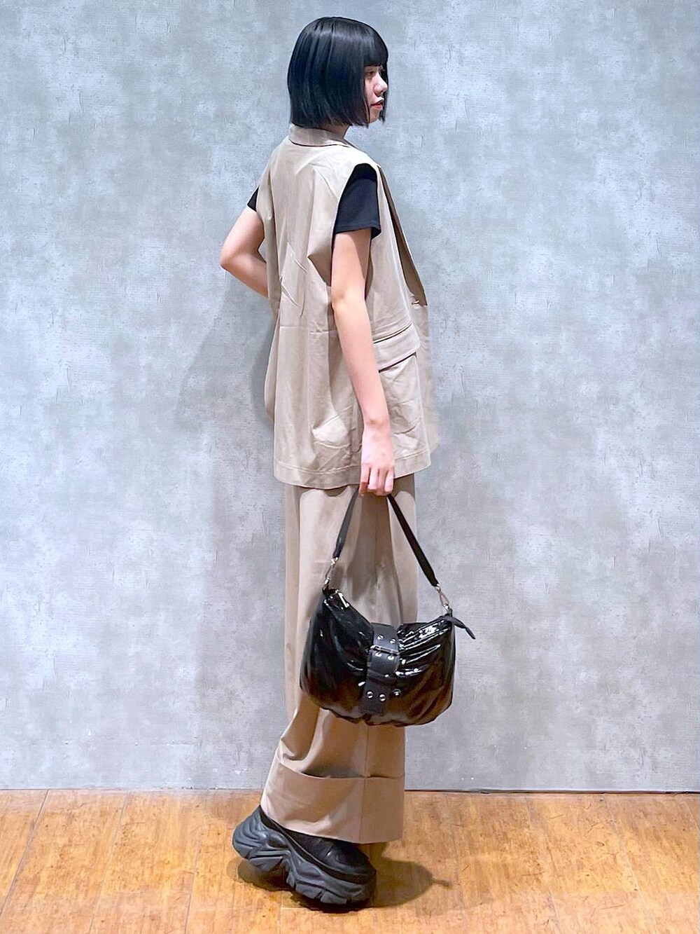 ブラック系のスニーカー、ブラック系のTシャツ/カットソー、ブラック系のショルダーバッグを着用したレディースの夏コーディネートの2枚目の写真