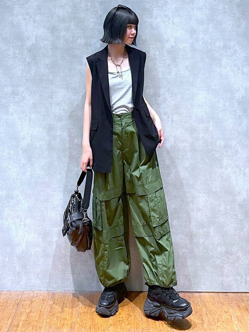 ブラック系のスニーカー、グリーン系のその他パンツ、ブラック系のショルダーバッグを着用したレディースの夏コーディネートの2枚目の写真