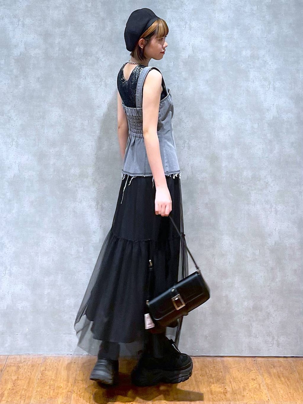 ブラック系のスニーカー、ブラック系のハンドバッグ、ブラック系のスカートを着用したレディースの夏コーディネートの6枚目の写真