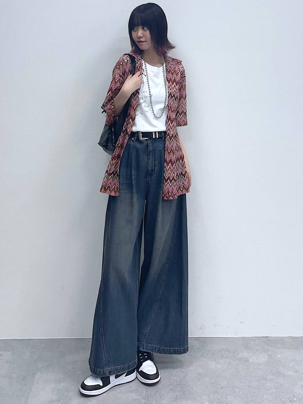 ピンク系のシャツ/ブラウス、ブルー系のデニムパンツ、ホワイト系のTシャツ/カットソーを着用したレディースの春コーディネートの2枚目の写真