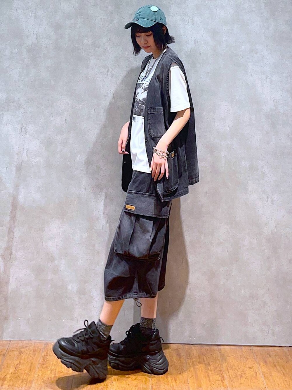 ブラック系のスニーカー、ホワイト系のTシャツ/カットソー、ブラック系のデニムパンツを着用したレディースの夏コーディネートの3枚目の写真