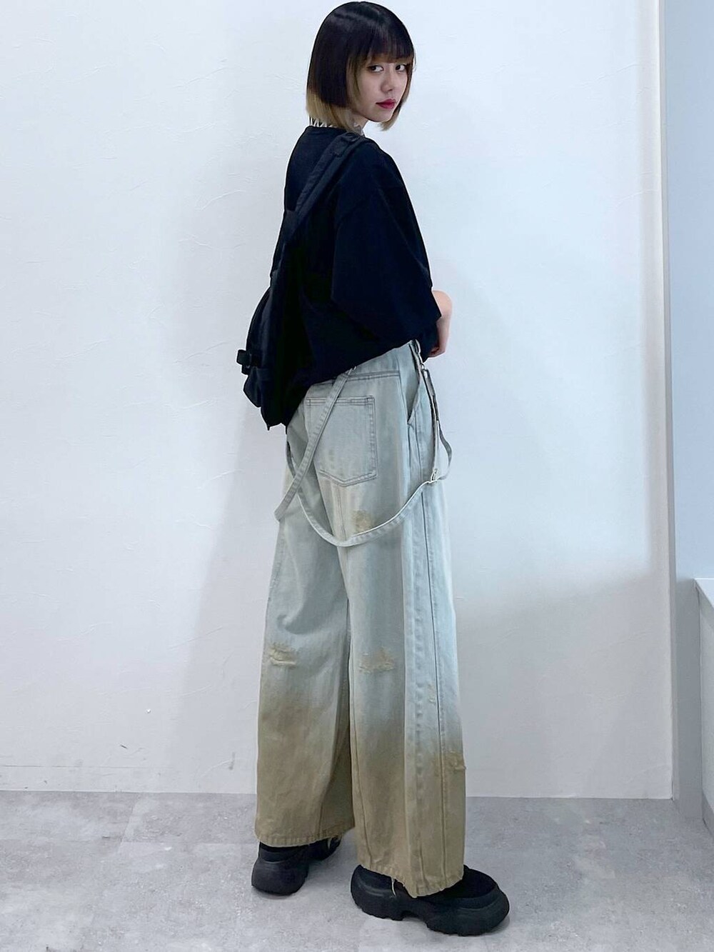 ブラック系のTシャツ/カットソー、ブラック系のボディバッグ/ウエストポーチ、ブラック系のブーツを着用したレディースの春コーディネートの5枚目の写真