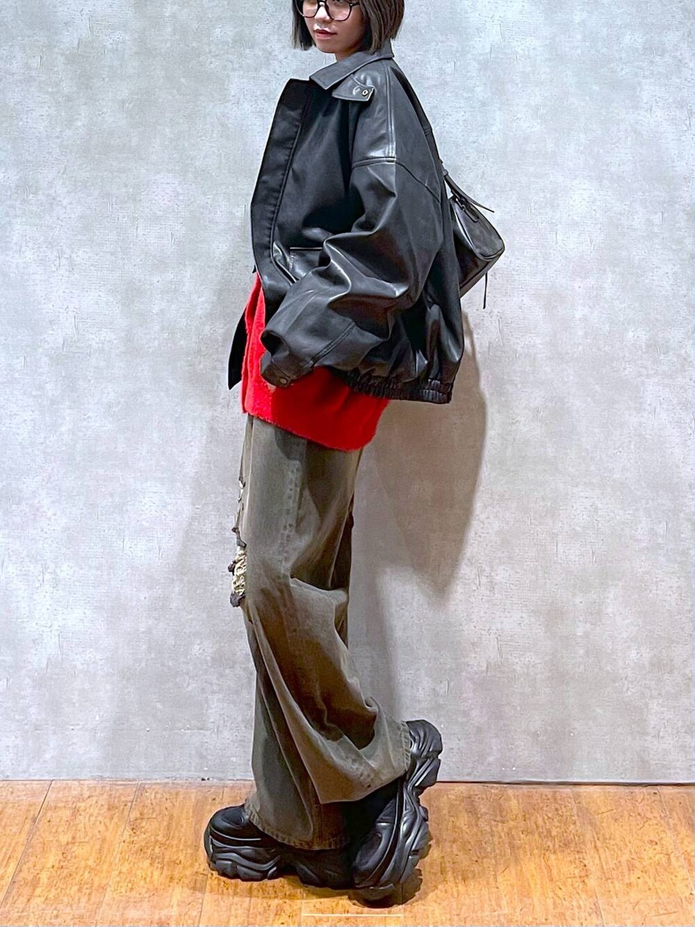 ブラック系のスニーカー、ブラック系のブルゾン、ブラック系のデニムパンツを着用したレディースの秋コーディネートの3枚目の写真