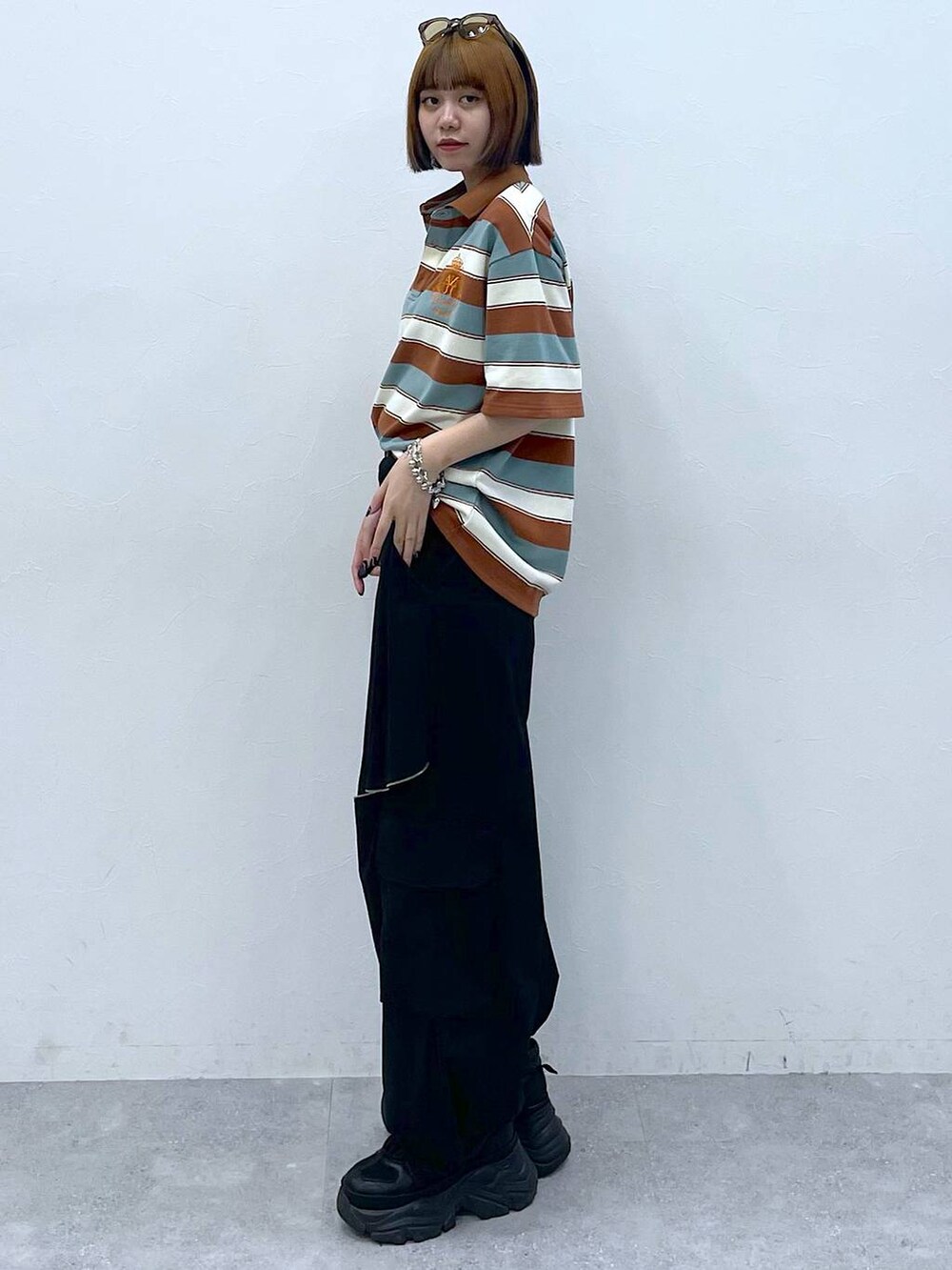 ブラック系のスニーカー、ブラック系のカーゴパンツ、ブラウン系のTシャツ/カットソーを着用したレディースの夏コーディネートの4枚目の写真