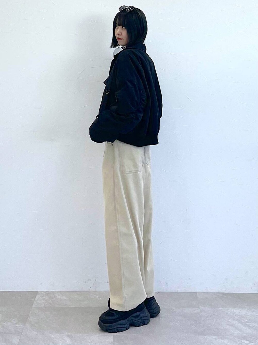 ブラック系のスニーカー、ブラック系のTシャツ/カットソー、ホワイト系のキャミソールを着用したレディースの秋コーディネートの4枚目の写真