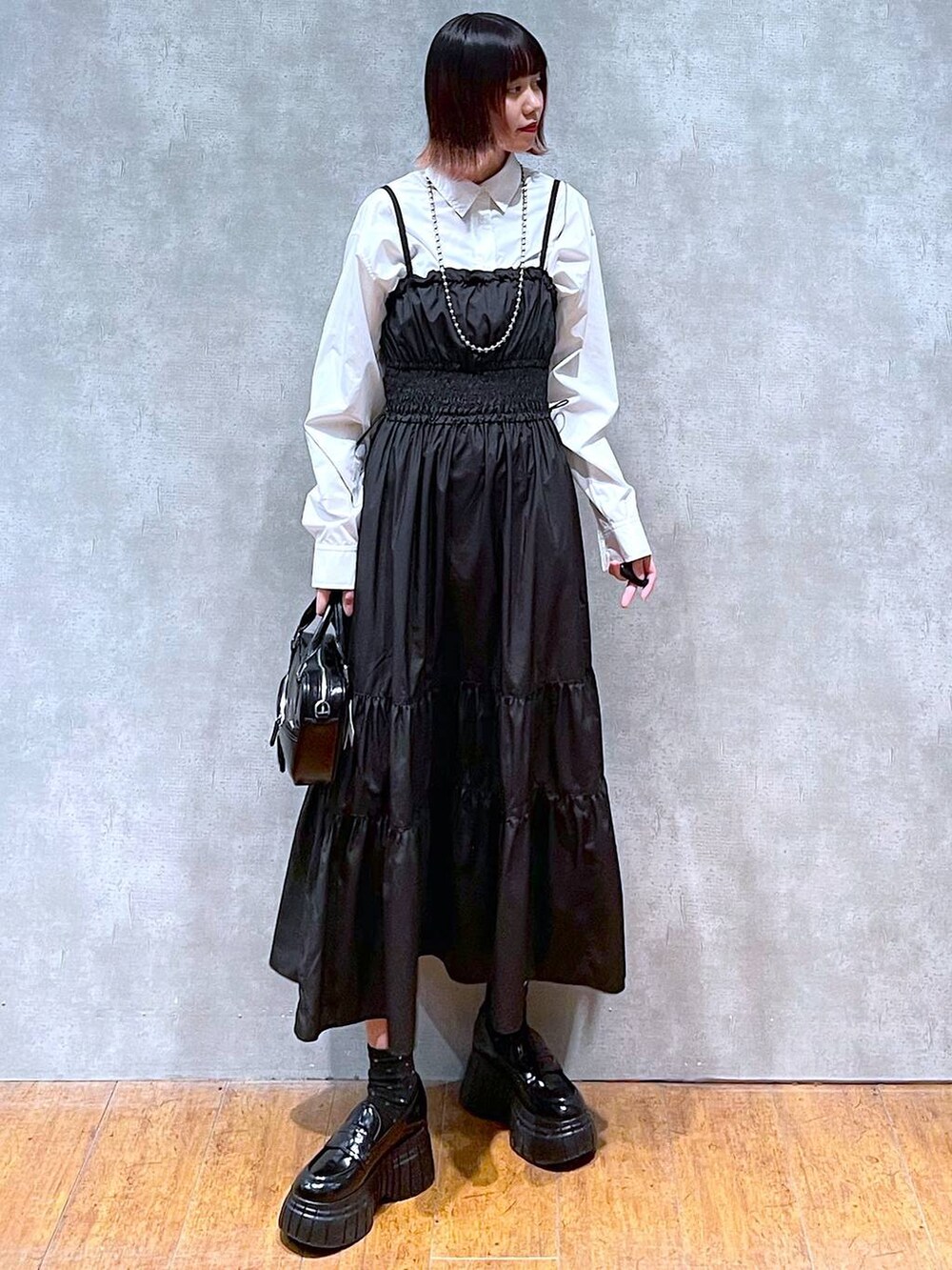 ホワイト系のシャツ/ブラウス、ブラック系のローファー、ブラック系のボストンバッグを着用したレディースの春コーディネートの2枚目の写真