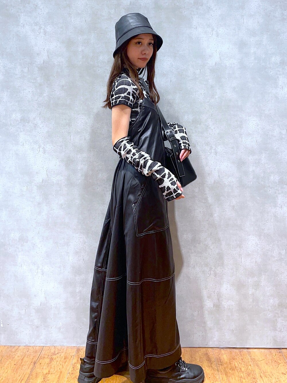 ブラック系のニット/セーター、ブラック系のショルダーバッグ、ブラック系のワンピースを着用したレディースの秋コーディネートの2枚目の写真