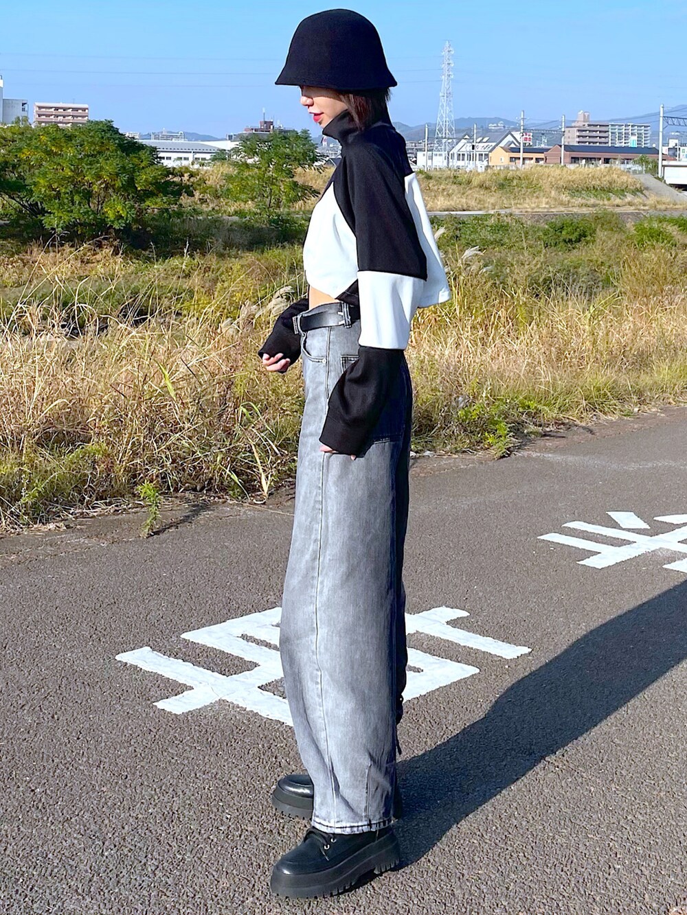 ブラック系のナイロンジャケット、ブラック系のキャミソール、ブラック系のデニムパンツを着用したレディースの秋コーディネートの2枚目の写真