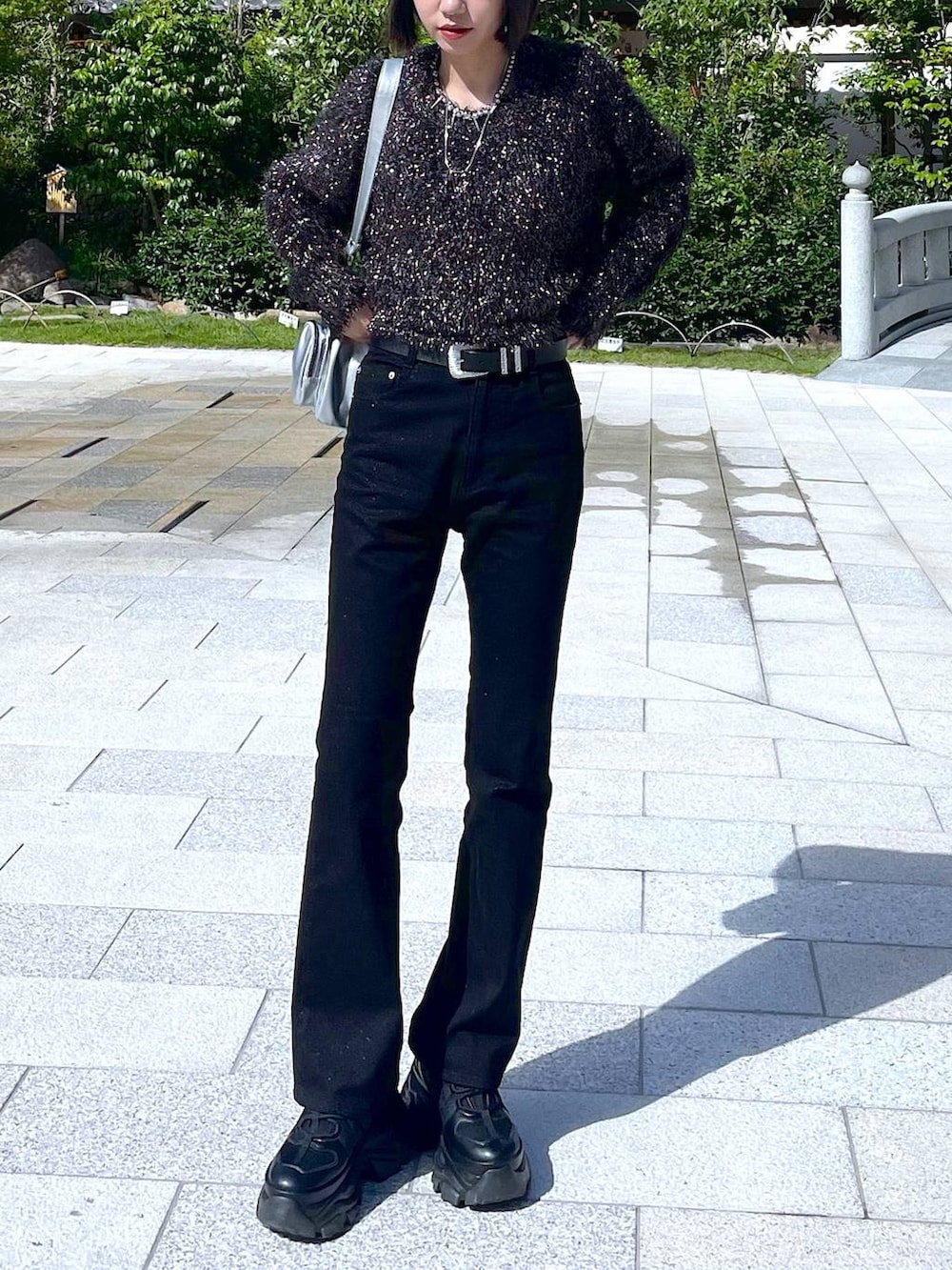 ブラック系のスニーカー、シルバー系のショルダーバッグ、ブラック系のニット/セーターを着用したレディースの秋コーディネートの6枚目の写真