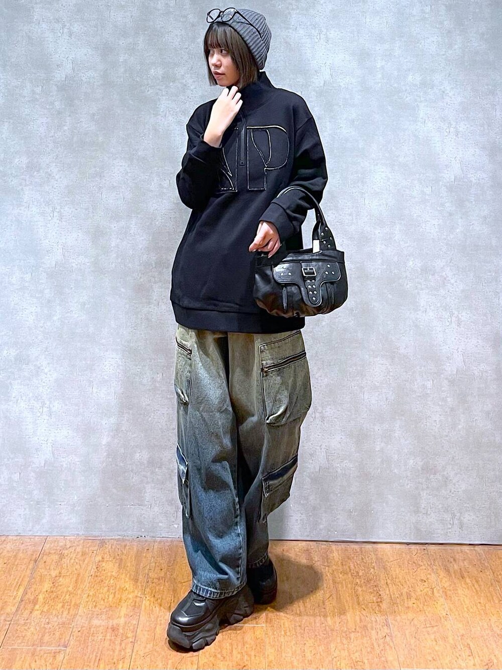 ブラック系のスニーカー、ブルー系のデニムパンツ、ブラック系のハンドバッグを着用したレディースの秋コーディネートの2枚目の写真