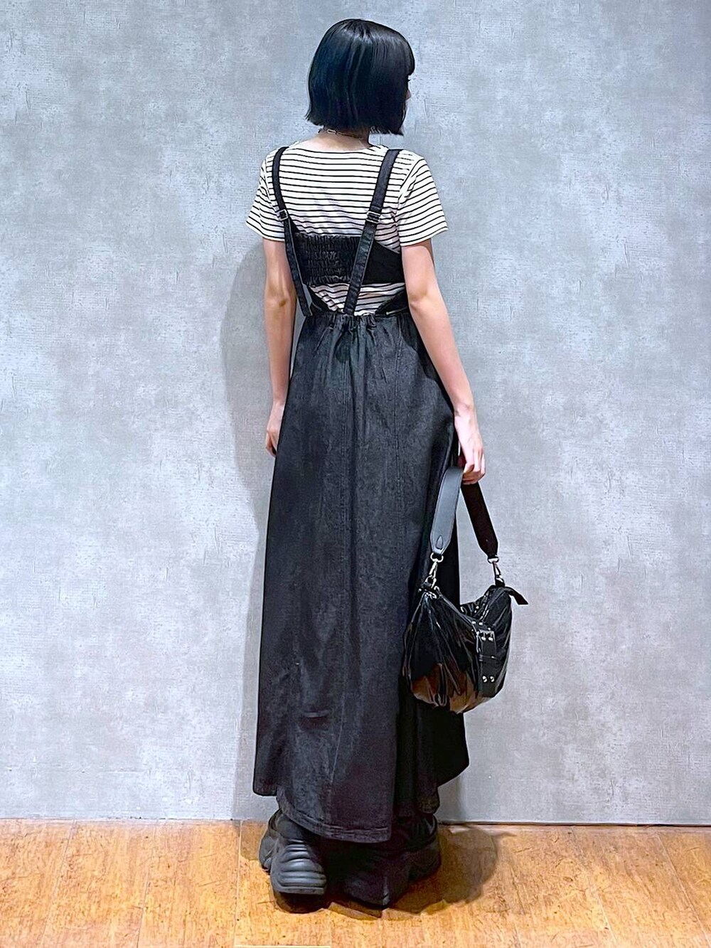 ブラック系のスニーカー、ブラック系のワンピース、ホワイト系のTシャツ/カットソーを着用したレディースの夏コーディネートの3枚目の写真