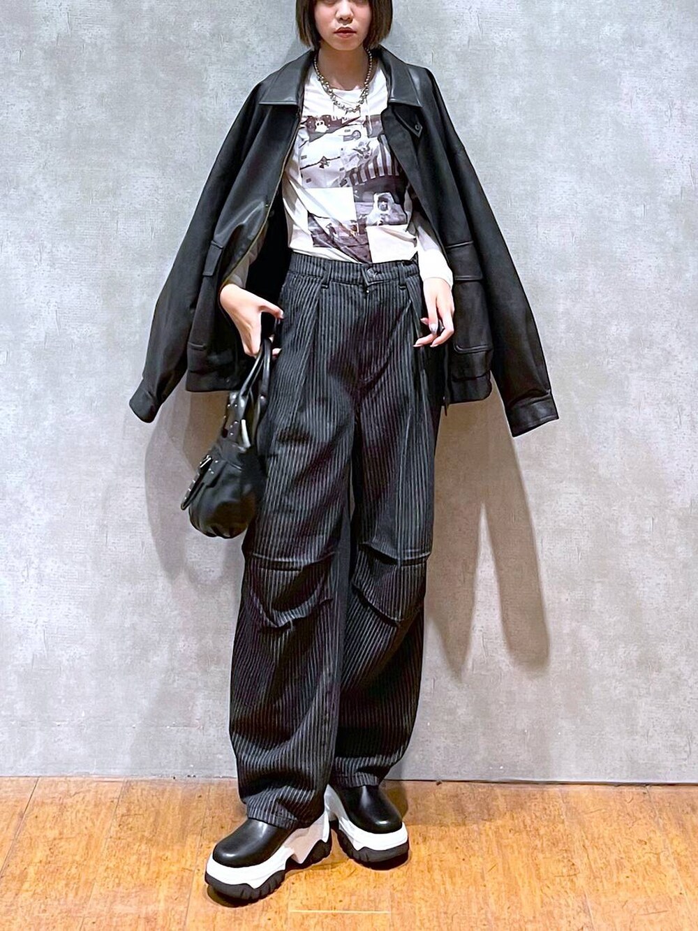 ブラック系のブルゾン、ブラック系のデニムパンツ、ブラック系のハンドバッグを着用したレディースの秋コーディネートの8枚目の写真