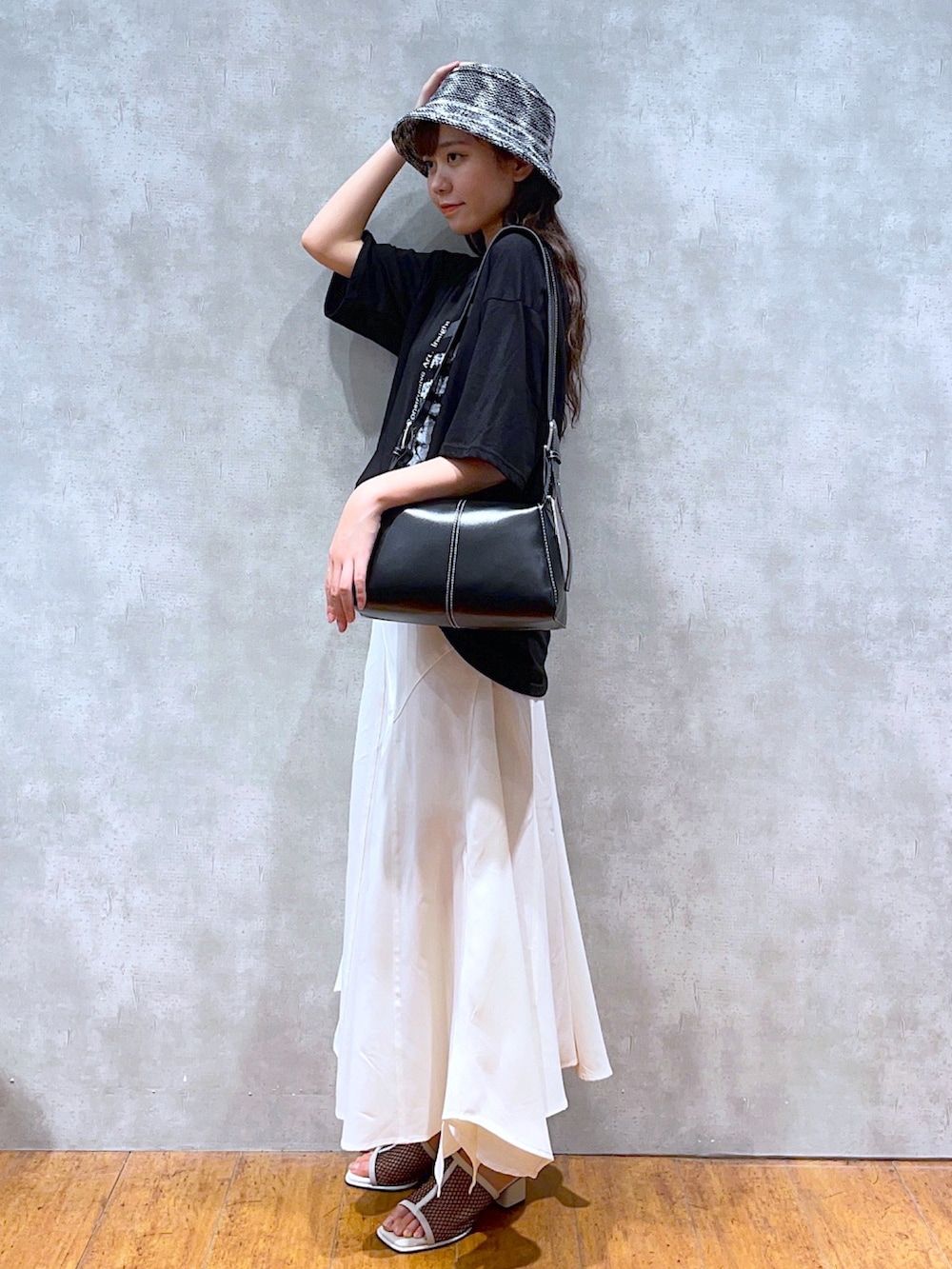 ブラック系のTシャツ/カットソー、ブラック系のショルダーバッグ、ホワイト系のスカートを着用したレディースの夏コーディネートの2枚目の写真