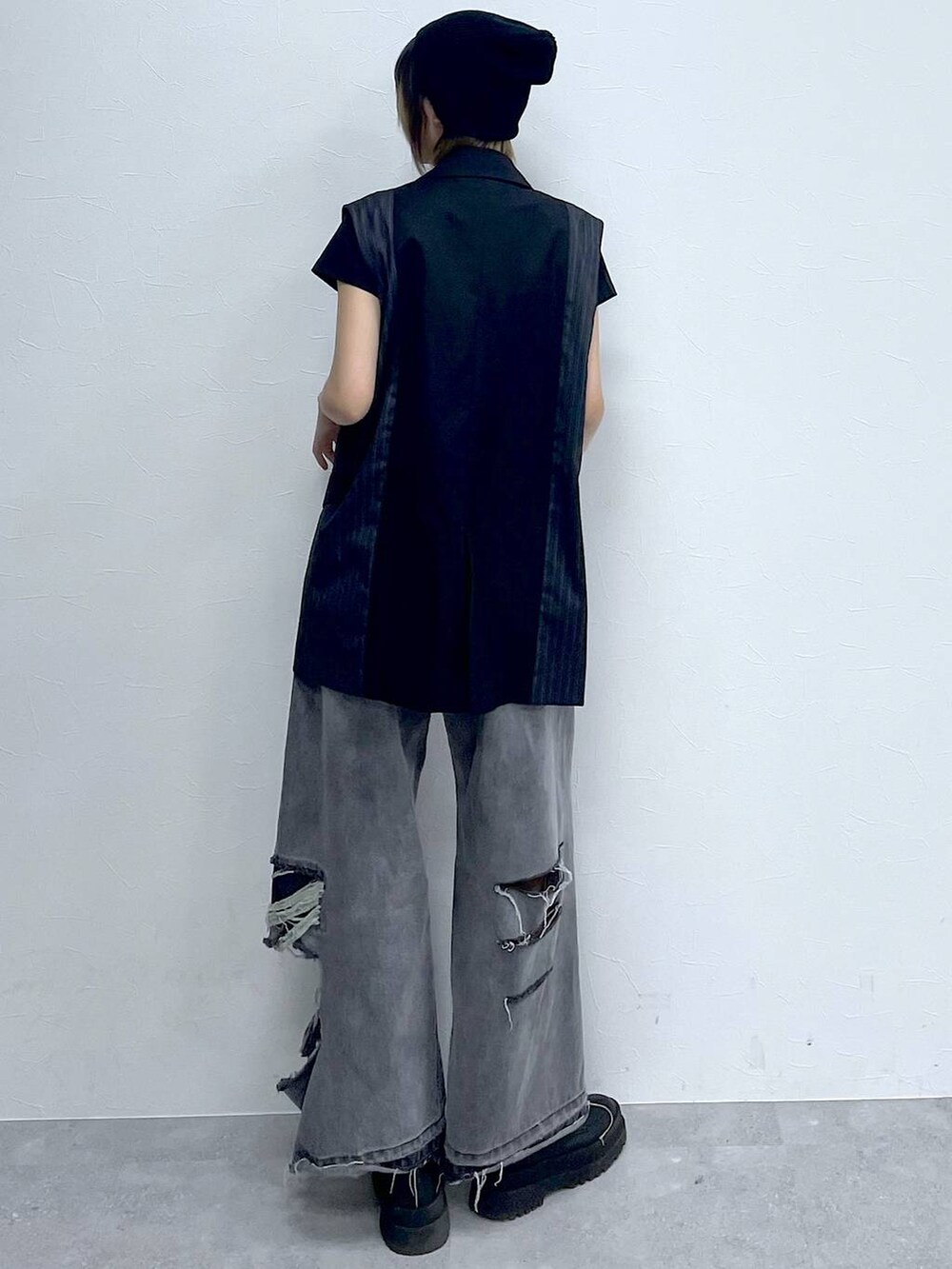 ブラック系のデニムパンツ、ブラック系のTシャツ/カットソー、ブラック系のブーツを着用したレディースの冬コーディネートの7枚目の写真