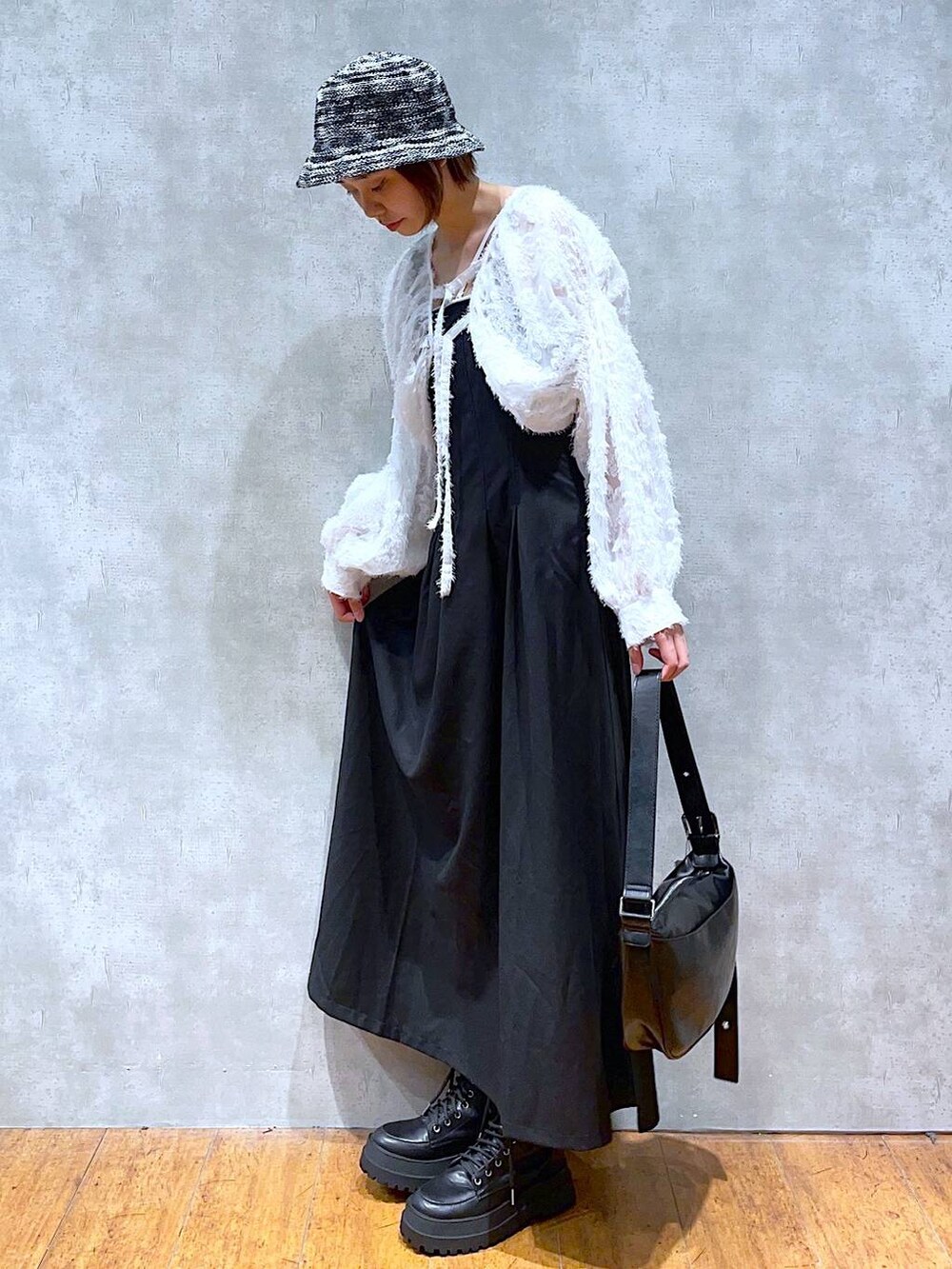 ブラック系のブーツ、ブラック系のショルダーバッグ、ブラック系のジャンパースカートを着用したレディースの夏コーディネートの3枚目の写真