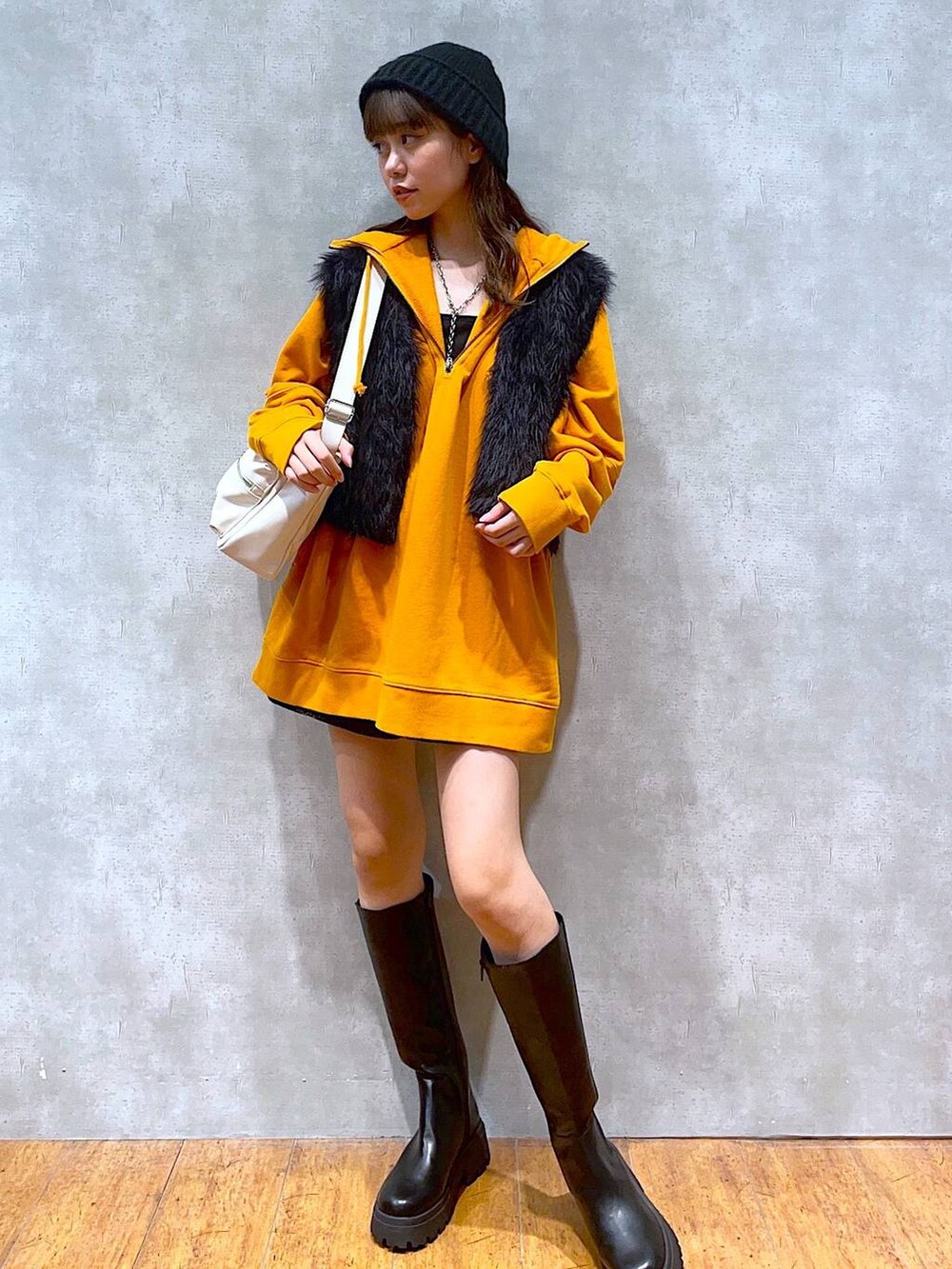 ホワイト系のショルダーバッグ、ブラック系のブーツ、ブラック系のその他パンツを着用したレディースの秋コーディネートの2枚目の写真