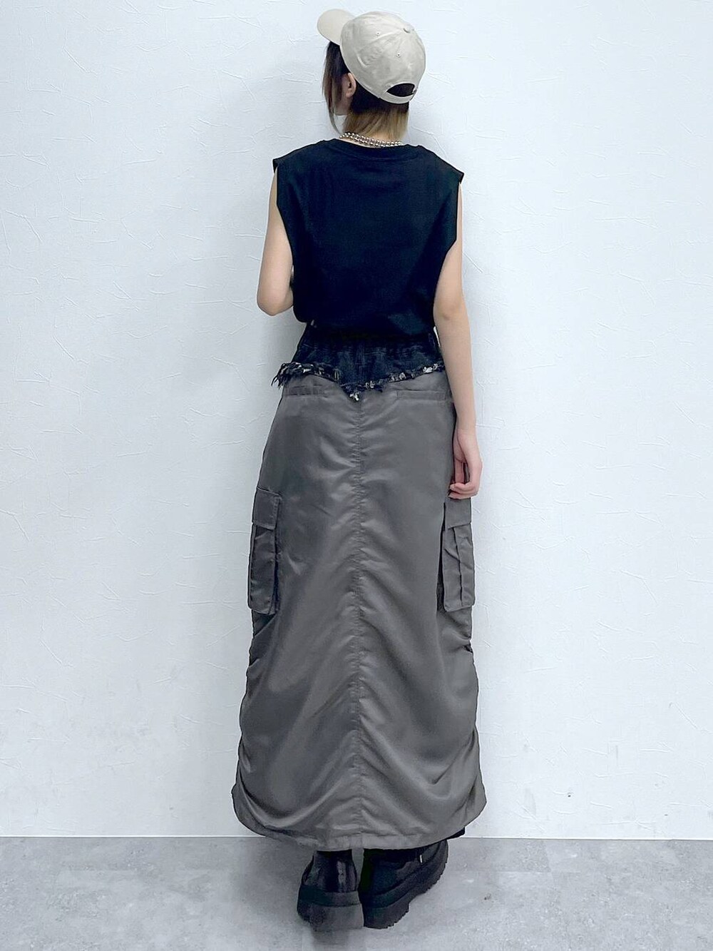 ブラック系のスラックス、ブラック系のTシャツ/カットソー、ブラック系のブーツを着用したレディースの春コーディネートの6枚目の写真