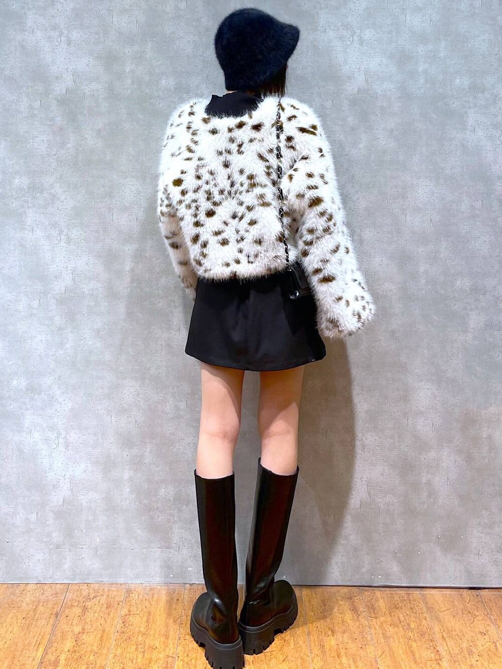 ブラック系のブーツ、ブラック系のニット/セーター、ブラウン系のブルゾンを着用したレディースの冬コーディネートの3枚目の写真