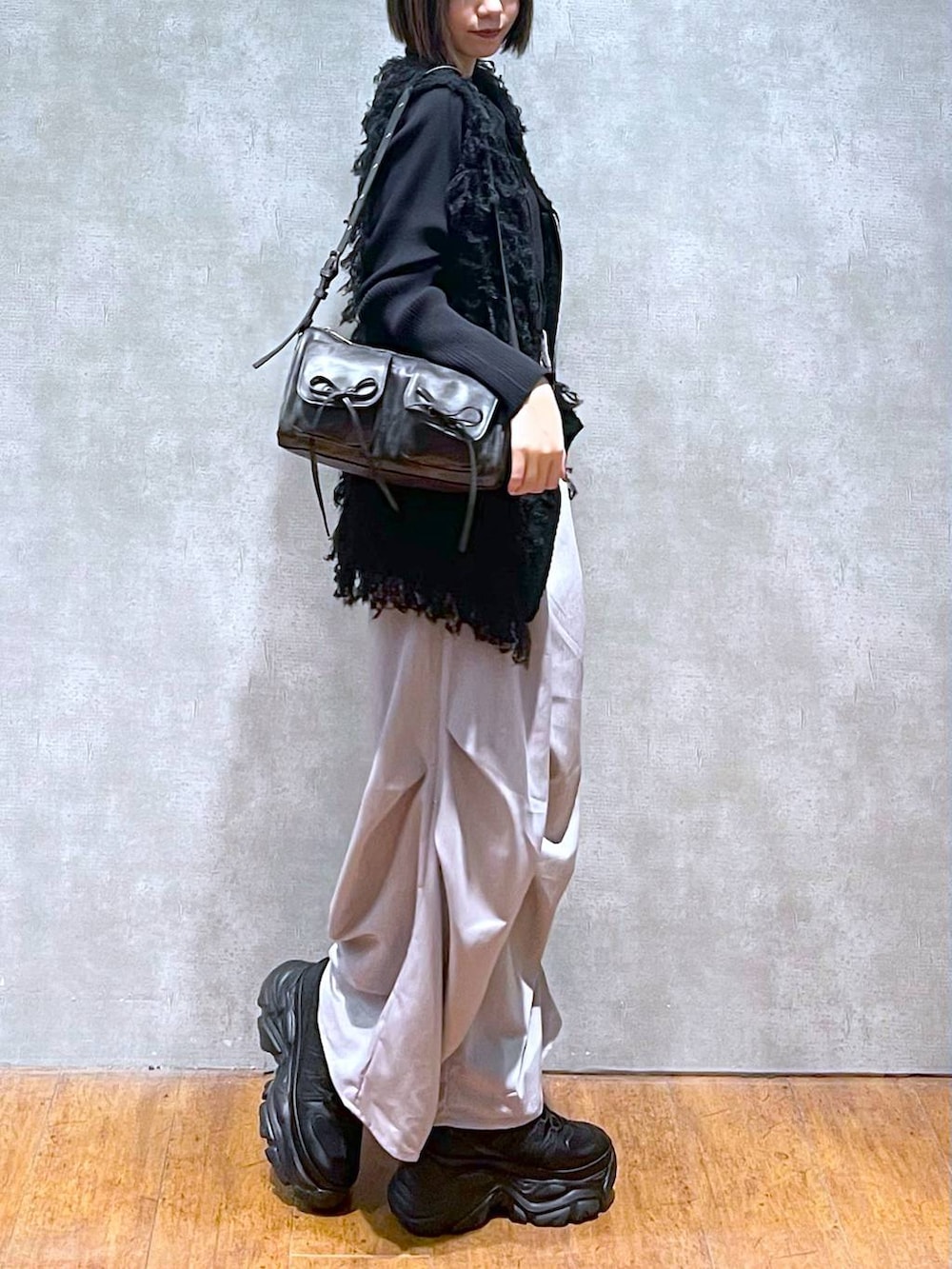 ブラック系のスニーカー、ブラック系のショルダーバッグ、グレー系のその他パンツを着用したレディースの秋コーディネートの3枚目の写真