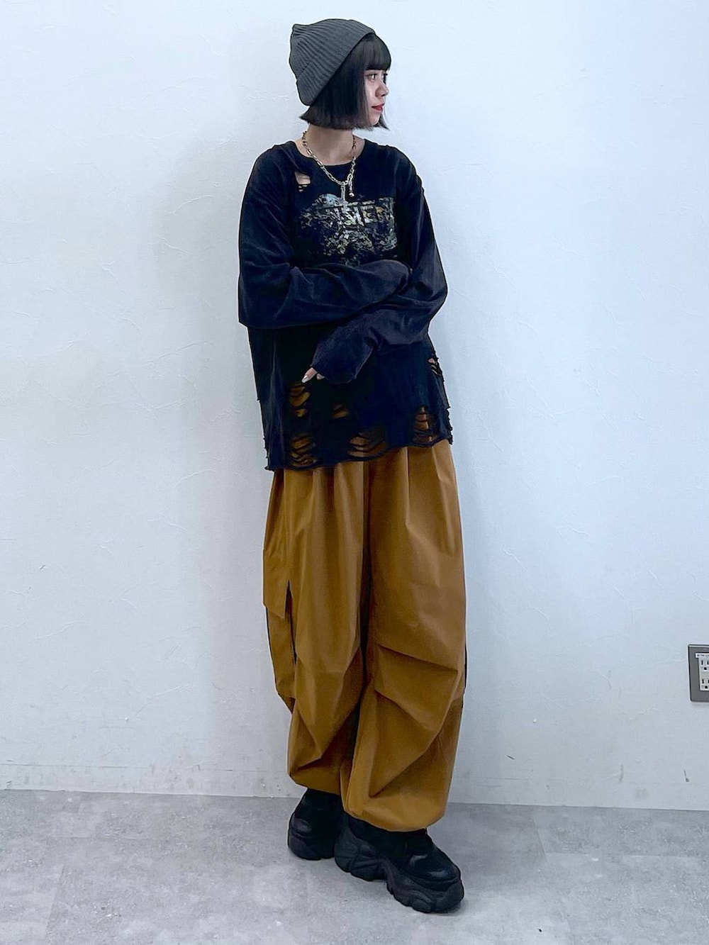 ブラック系のスニーカー、ブラウン系のカーゴパンツ、ブラック系のTシャツ/カットソーを着用したレディースの夏コーディネートの2枚目の写真