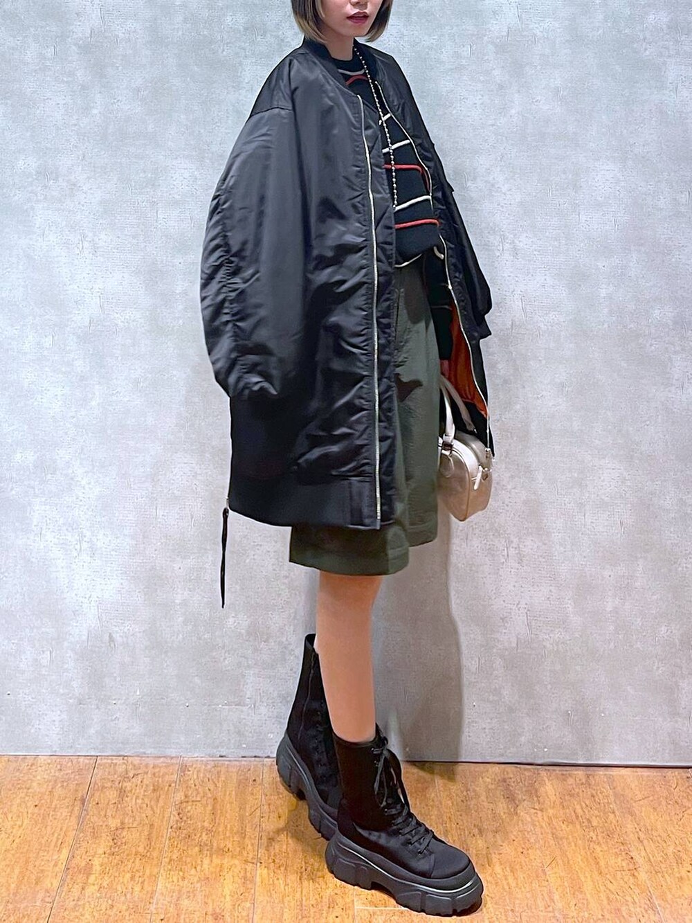 グリーン系のカーゴパンツ、ブラック系のMA-1、ブラック系のニット/セーターを着用したレディースの冬コーディネートの4枚目の写真