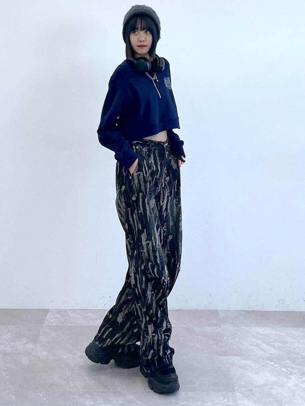 ブラック系のスニーカー、ブラック系のデニムパンツ、ホワイト系のキャミソールを着用したレディースの秋コーディネートの5枚目の写真