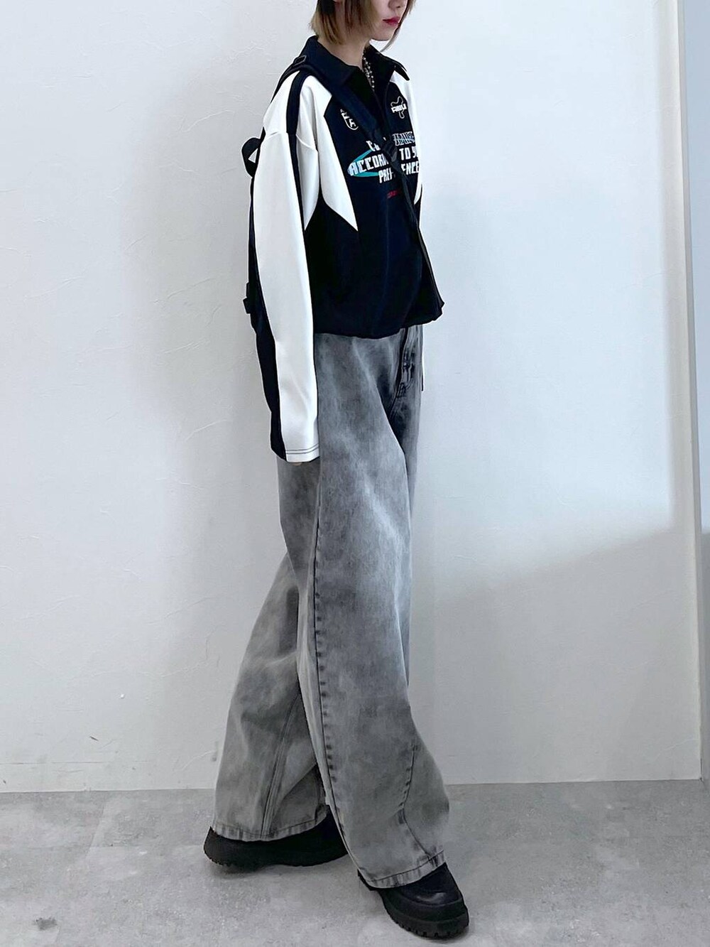 ブラック系のデニムパンツ、ブラック系のボディバッグ/ウエストポーチ、ブラック系のブーツを着用したレディースの冬コーディネートの7枚目の写真