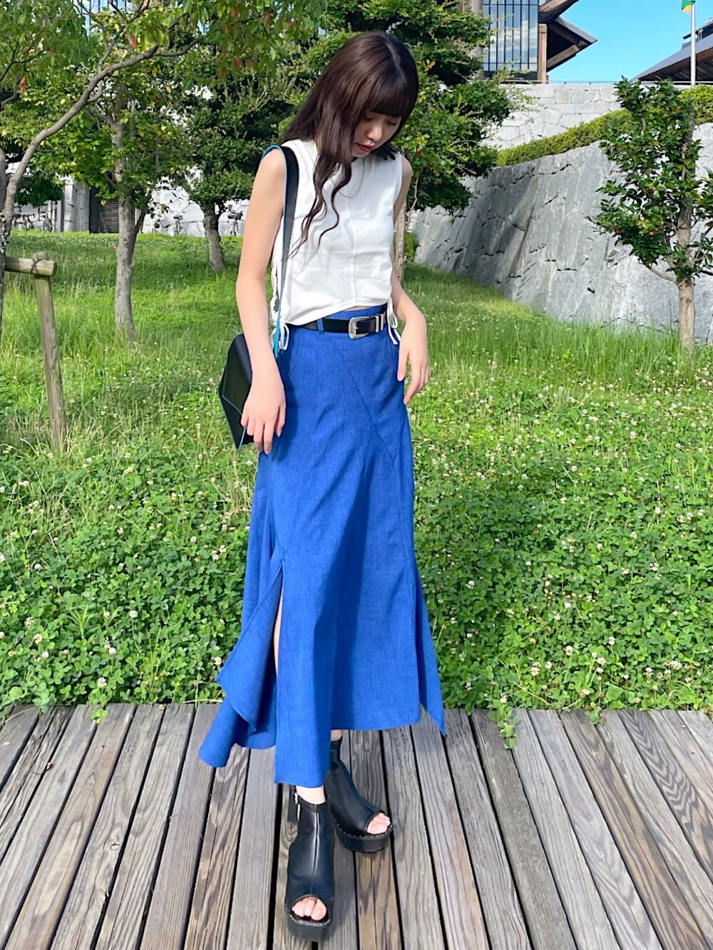 ホワイト系のTシャツ/カットソー、ブラック系のショルダーバッグ、ブルー系のスカートを着用したレディースの夏コーディネートの2枚目の写真