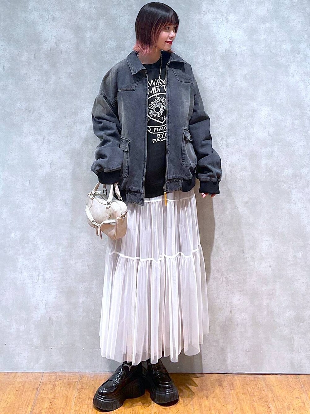 ブラック系のニット/セーター、ブラック系のデニムジャケット、ホワイト系のスカートを着用したレディースの冬コーディネートの2枚目の写真