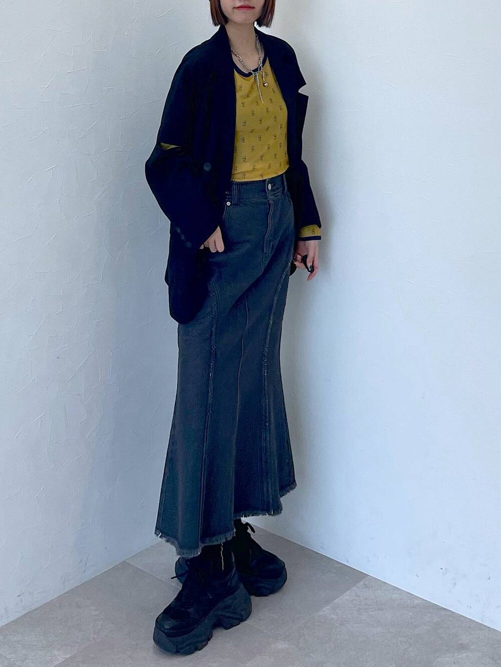 ブラック系のスニーカー、ブラック系のデニムスカート、イエロー系のTシャツ/カットソーを着用したレディースの夏コーディネートの6枚目の写真