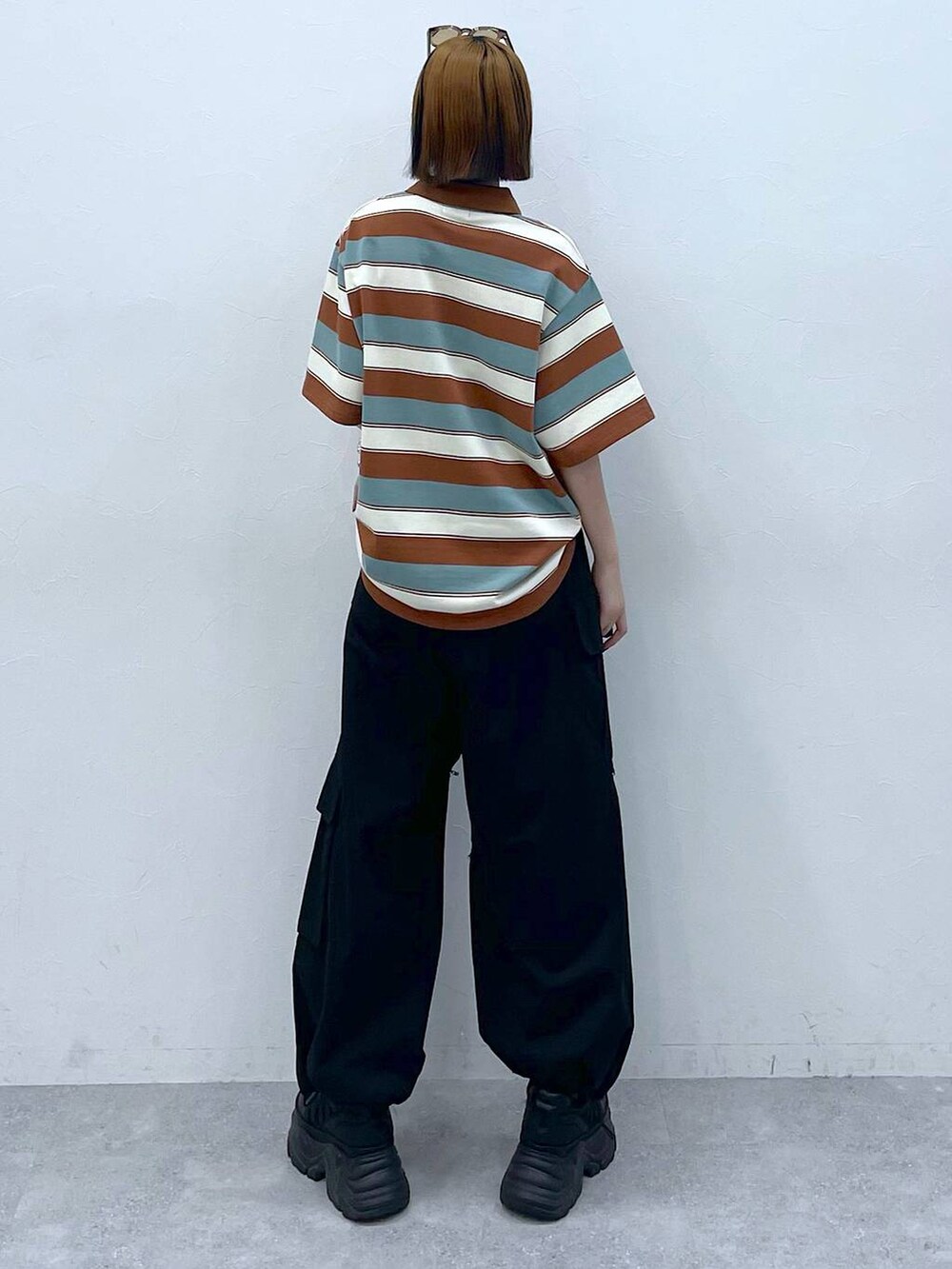 ブラック系のスニーカー、ブラック系のカーゴパンツ、ブラウン系のTシャツ/カットソーを着用したレディースの夏コーディネートの6枚目の写真