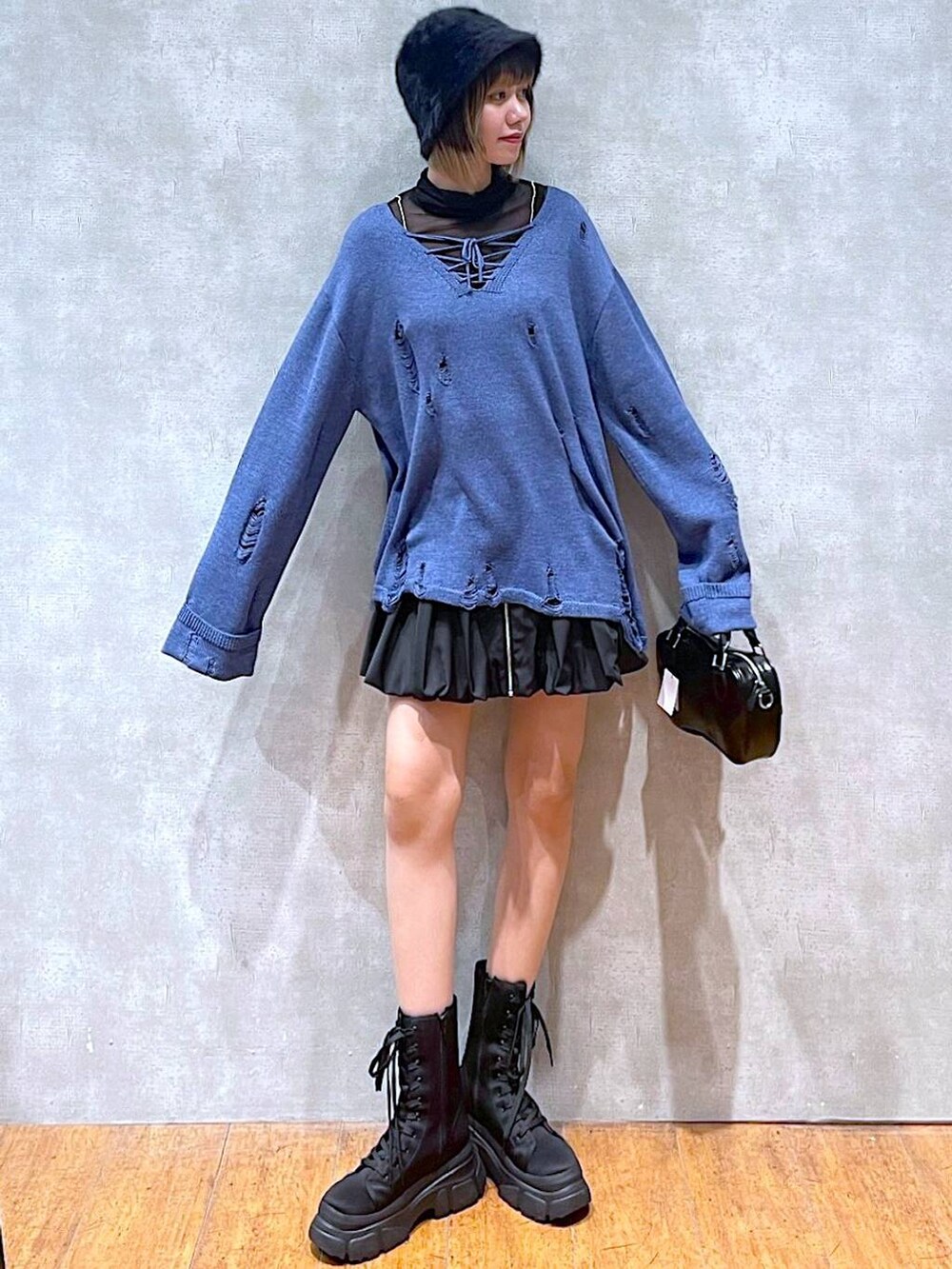 ブラック系のTシャツ/カットソー、ブラック系のスカート、ブラック系のボストンバッグを着用したレディースの冬コーディネートの4枚目の写真