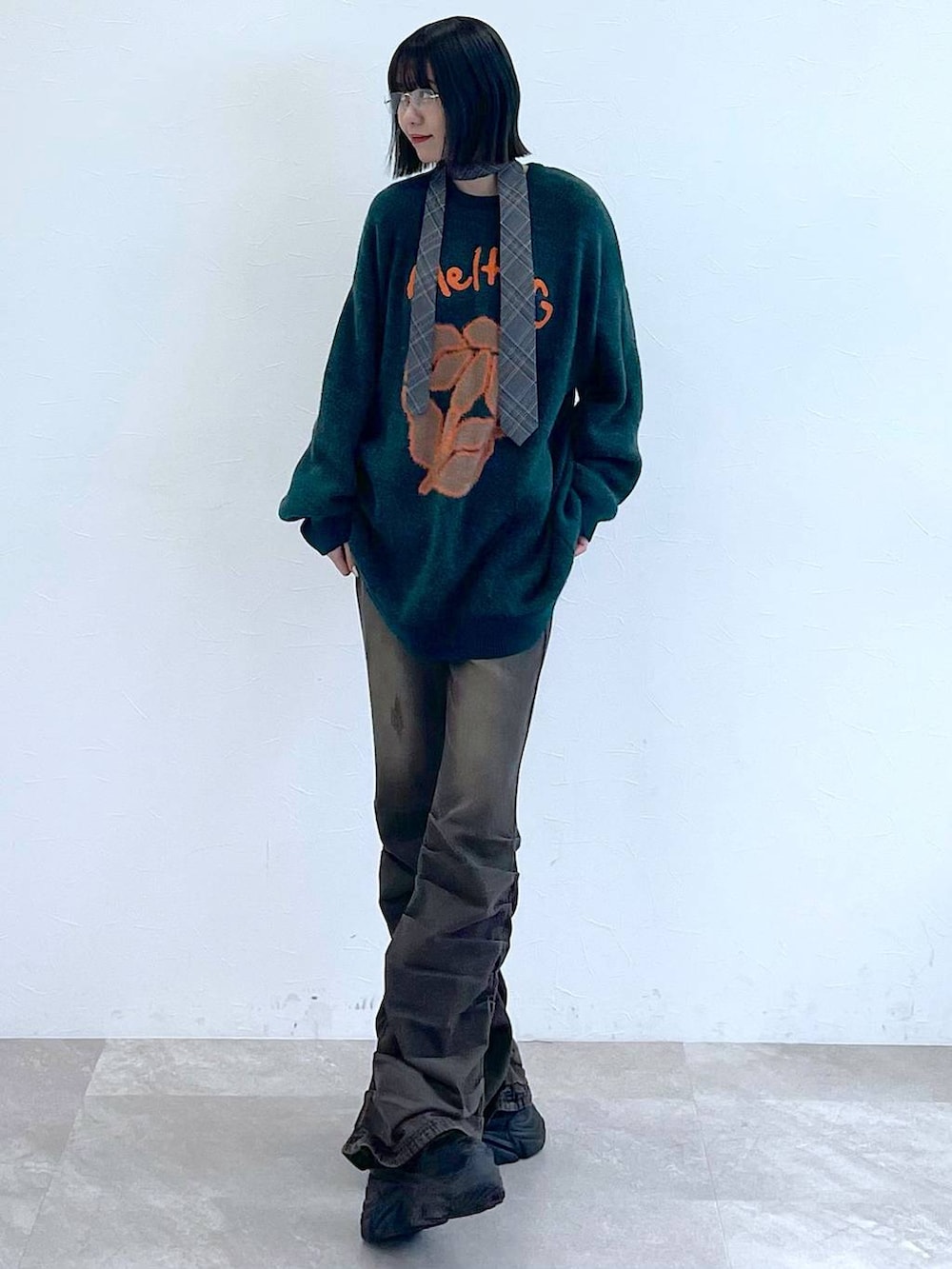 ブラック系のスニーカー、グレー系のネクタイ、ブラック系のデニムパンツを着用したレディースの秋コーディネートの3枚目の写真