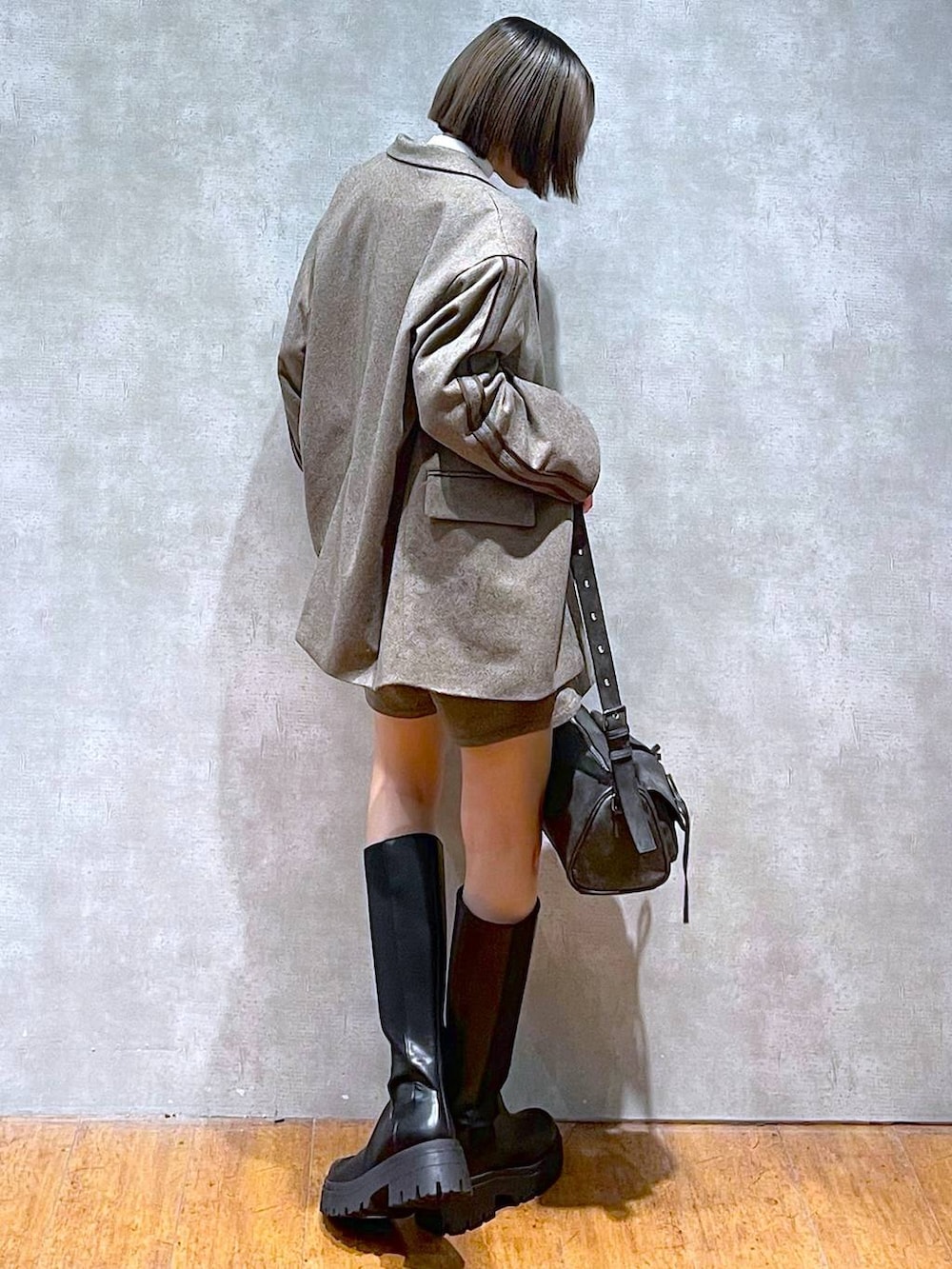 ブラック系のショルダーバッグ、ホワイト系のニット/セーター、ブラック系のブーツを着用したレディースの秋コーディネートの3枚目の写真