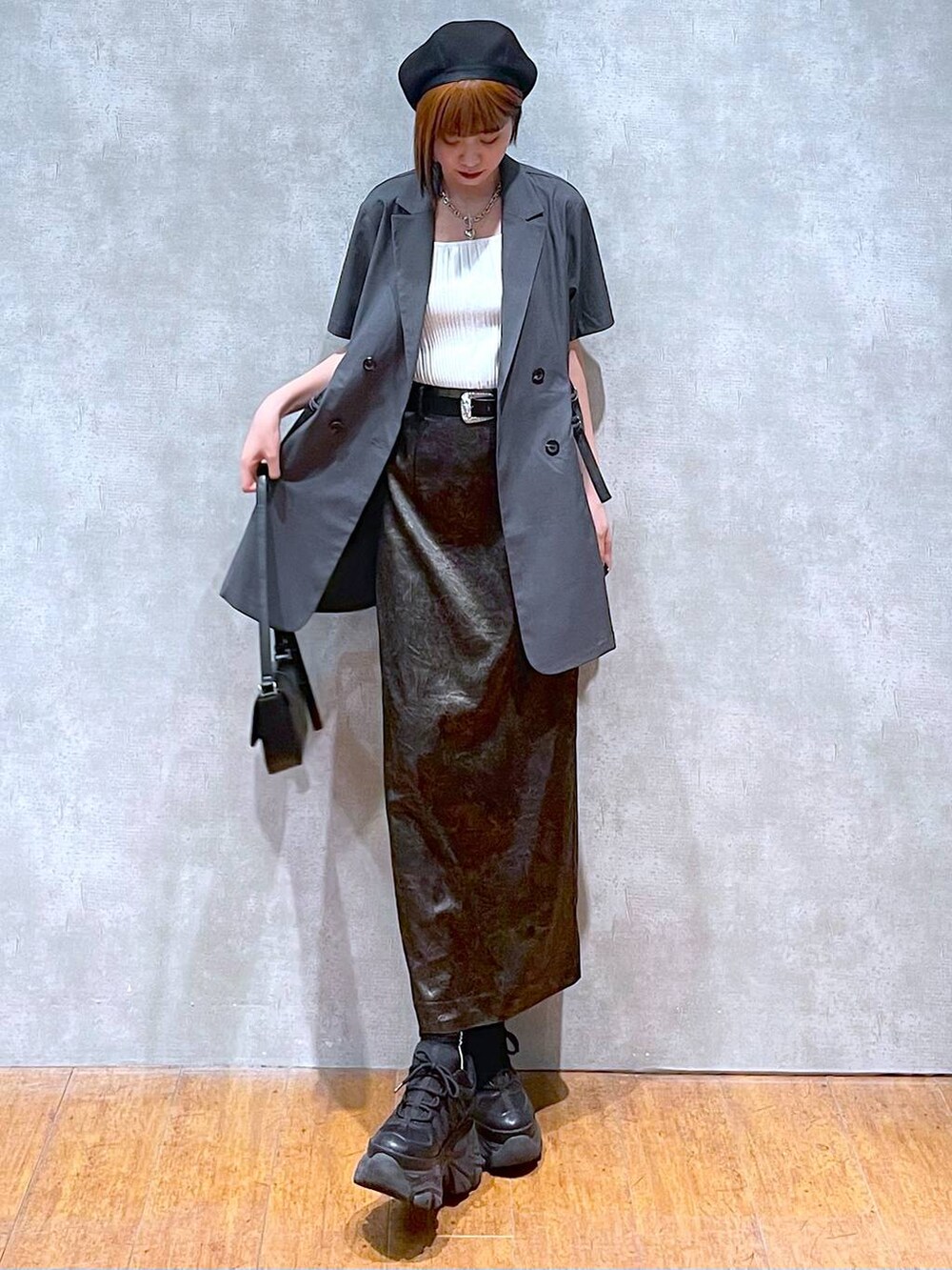 ホワイト系のタンクトップ、ブラック系のスニーカー、ブラック系のハンドバッグを着用したレディースの夏コーディネートの6枚目の写真