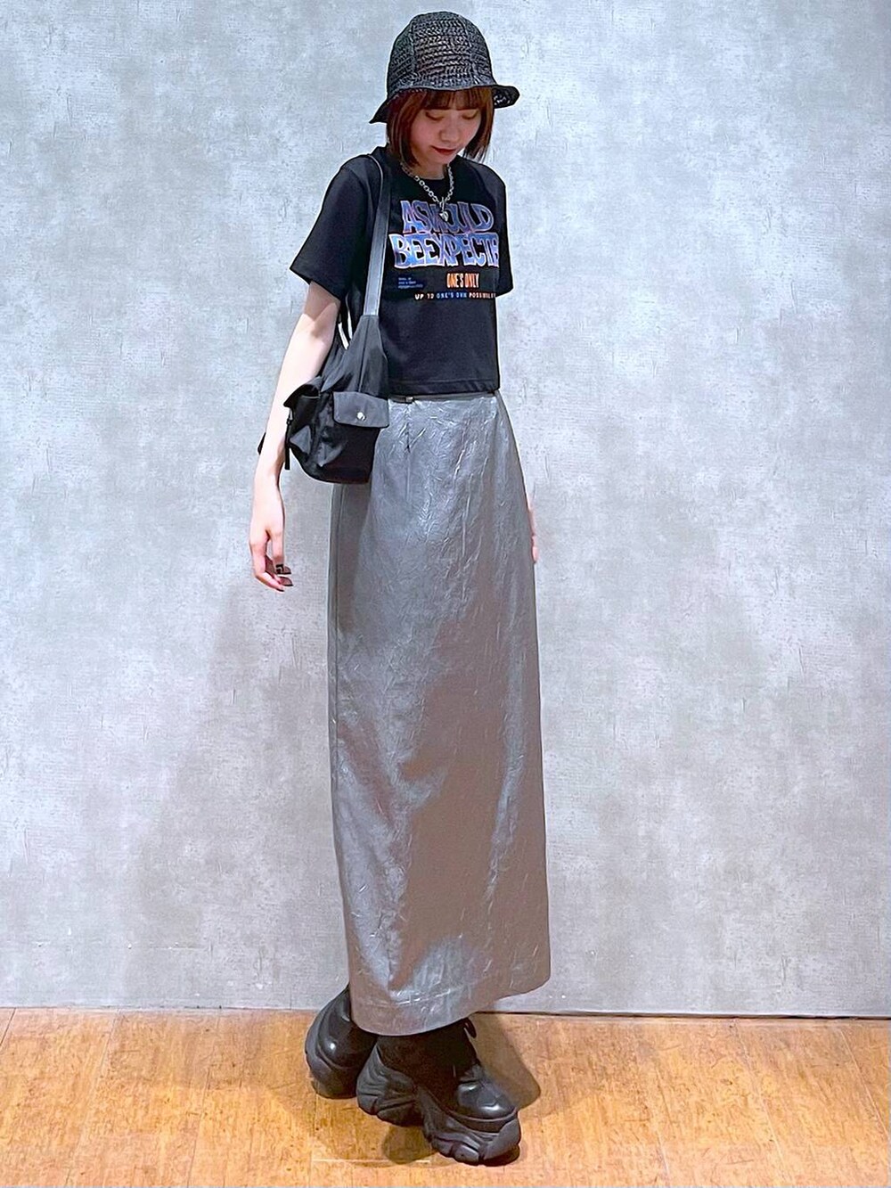 ブラック系のショルダーバッグ、ブラック系のスニーカー、ブルー系のスカートを着用したレディースの夏コーディネートの4枚目の写真