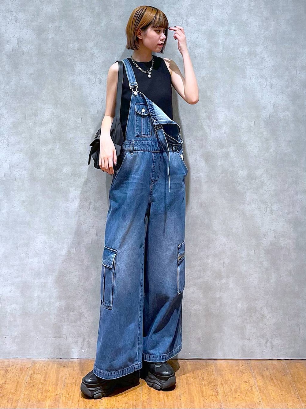 ブラック系のショルダーバッグ、ブラック系のスニーカー、ブラック系のタンクトップを着用したレディースの夏コーディネートの2枚目の写真