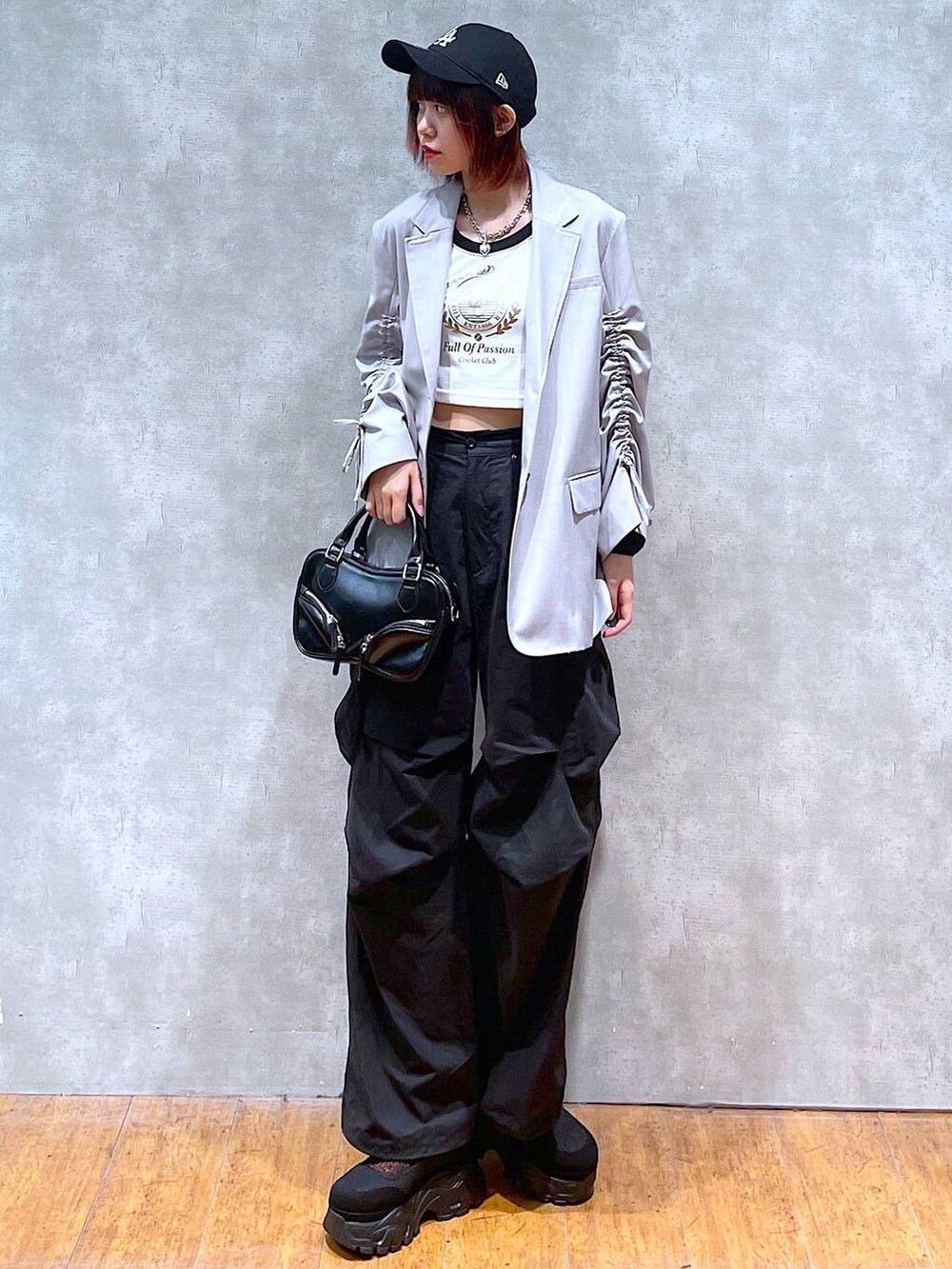 ベージュ系のテーラードジャケット、ホワイト系のTシャツ/カットソー、ブラック系のカーゴパンツを着用したレディースの春コーディネートの2枚目の写真