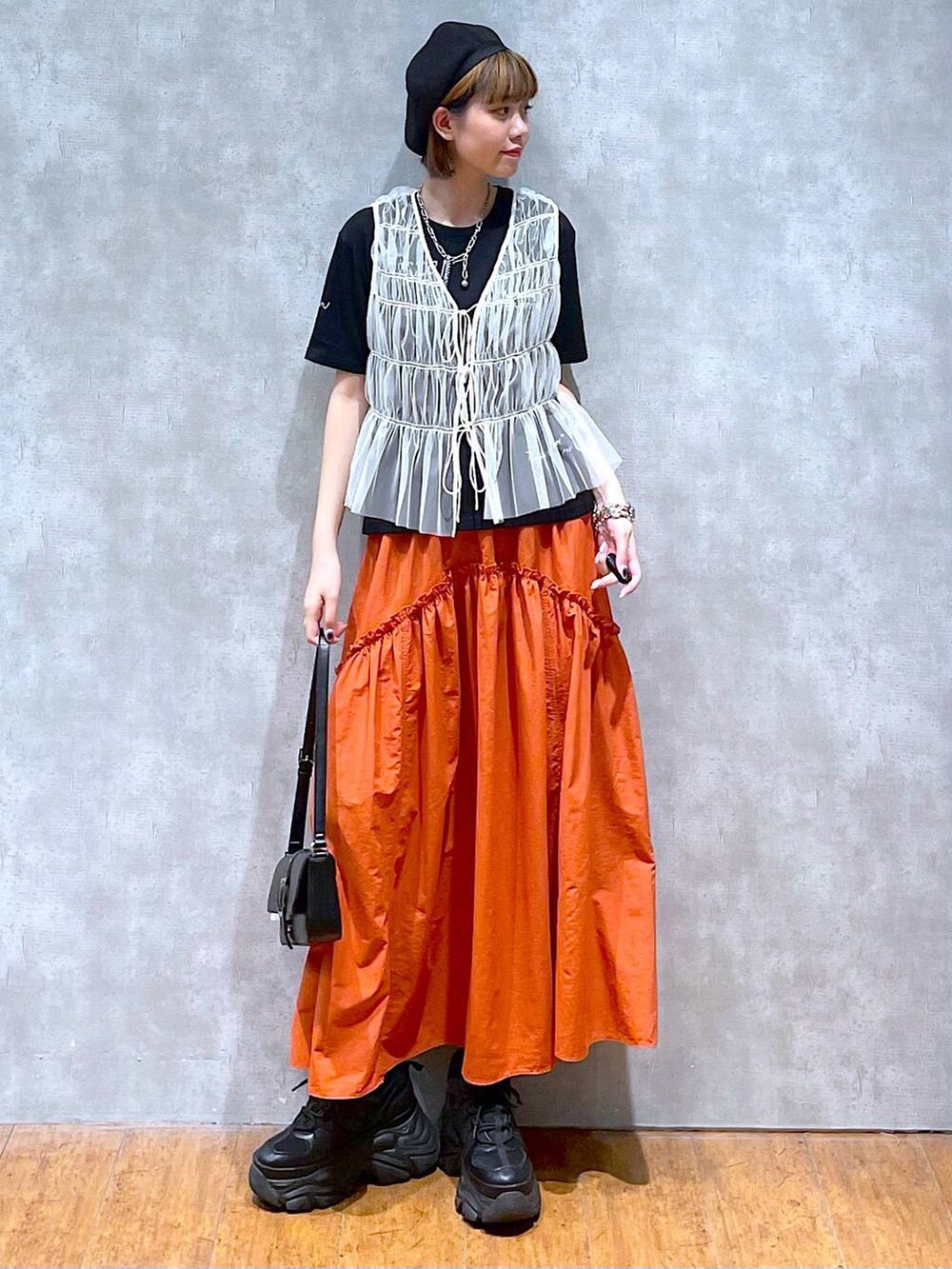 ブラック系のスニーカー、ブラック系のハンドバッグ、ブラック系のTシャツ/カットソーを着用したレディースの夏コーディネートの2枚目の写真