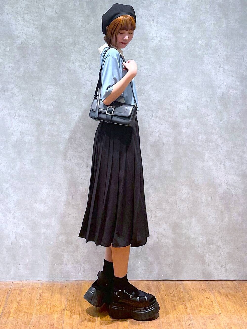 ブラック系のスニーカー、ブラック系のスカート、ブラック系のハンドバッグを着用したレディースの夏コーディネートの4枚目の写真
