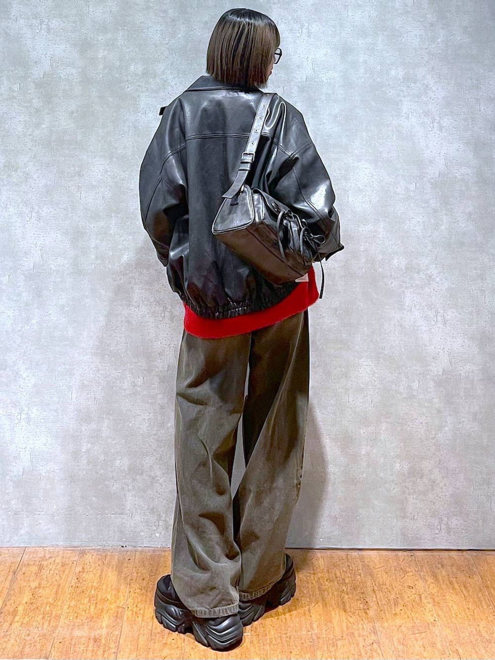 ブラック系のスニーカー、ブラック系のブルゾン、ブラック系のデニムパンツを着用したレディースの秋コーディネートの6枚目の写真