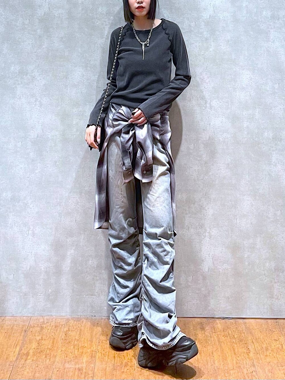 ブラック系のスニーカー、ブルー系のデニムパンツ、グレー系のシャツ/ブラウスを着用したレディースの秋コーディネートの9枚目の写真