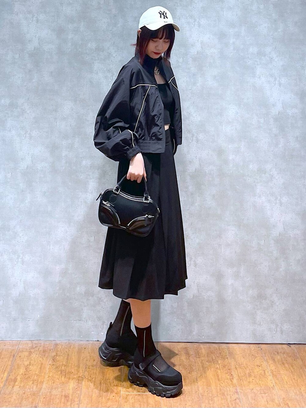 ブラック系のブルゾン、ブラック系のスカート、ブラック系のキャミソールを着用したレディースの春コーディネートの3枚目の写真