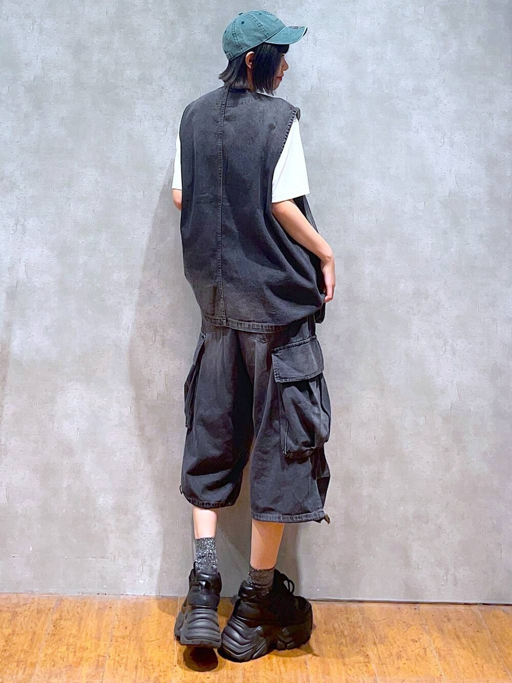ブラック系のスニーカー、ホワイト系のTシャツ/カットソー、ブラック系のデニムパンツを着用したレディースの夏コーディネートの5枚目の写真