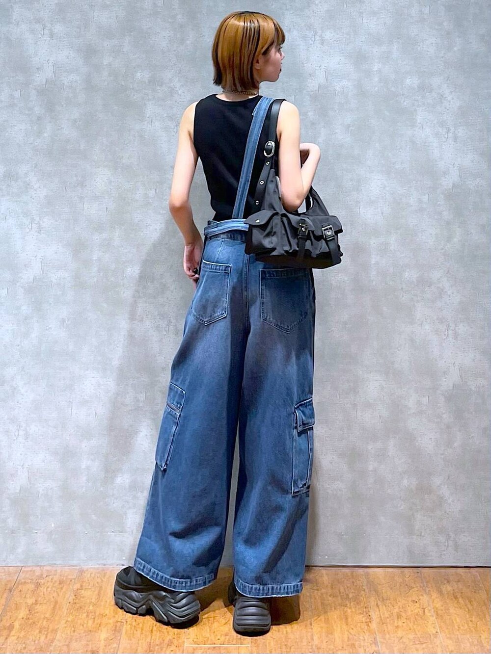 ブラック系のショルダーバッグ、ブラック系のスニーカー、ブラック系のタンクトップを着用したレディースの夏コーディネートの4枚目の写真