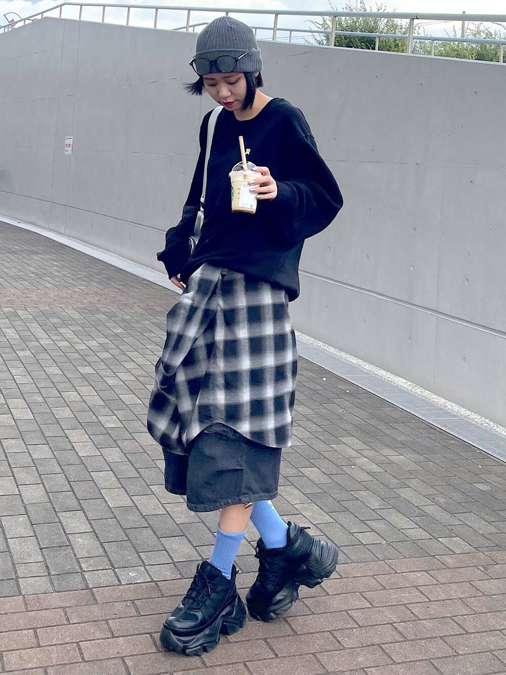 ブラック系のスニーカー、ブラック系のシャツ/ブラウス、ブラック系のデニムパンツを着用したレディースの秋コーディネートの9枚目の写真