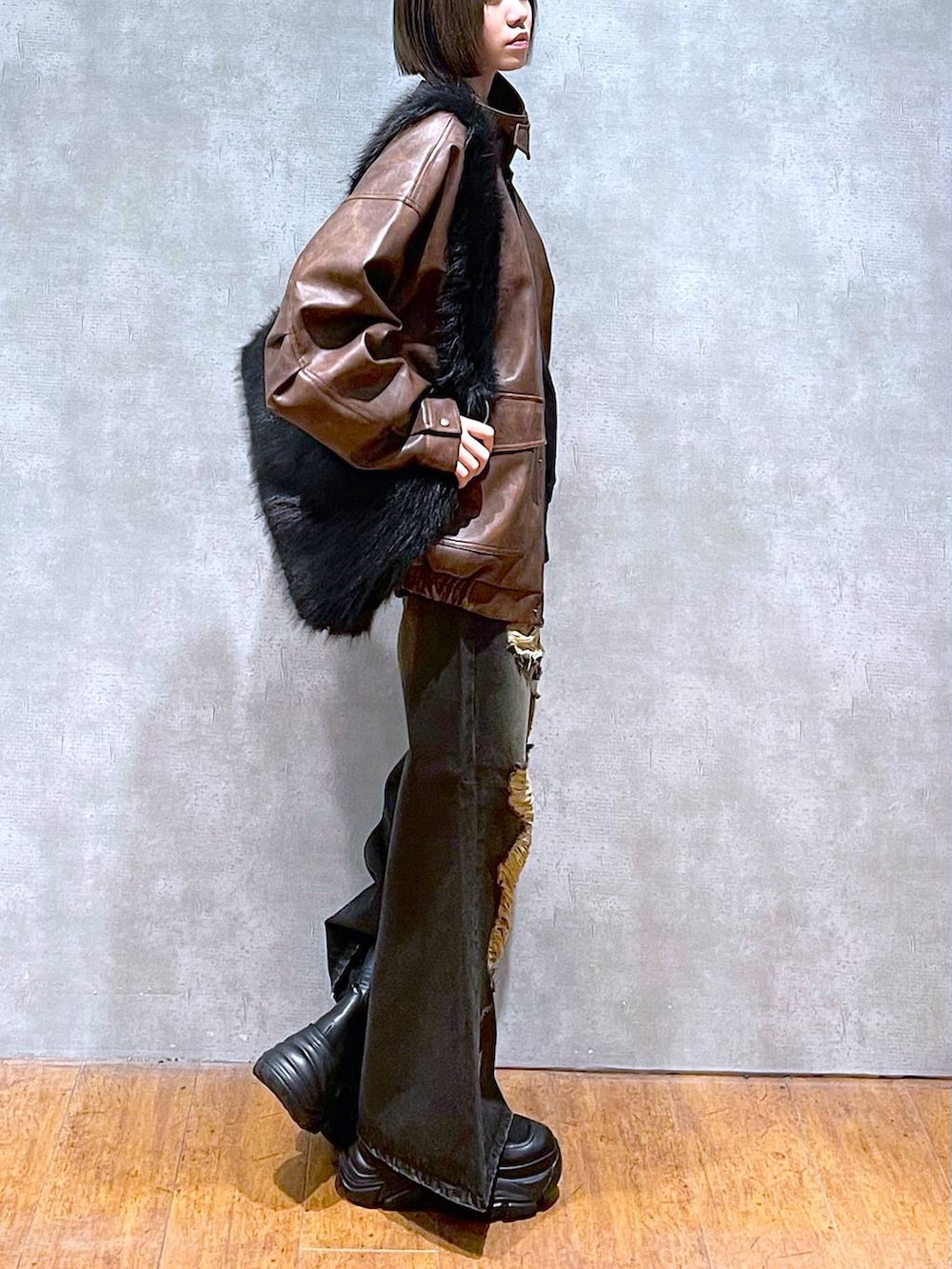 ブラウン系のブルゾン、ブラック系のブーツ、グレー系のスウェットを着用したレディースの秋コーディネートの5枚目の写真